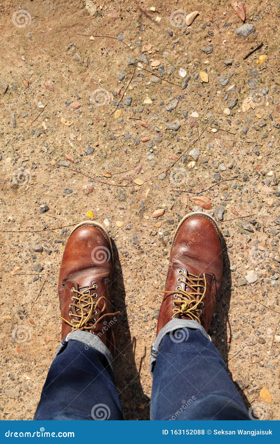 Usando Botas Cuero Parado En Una Carretera De Campo Foto de archivo - Imagen de azul: