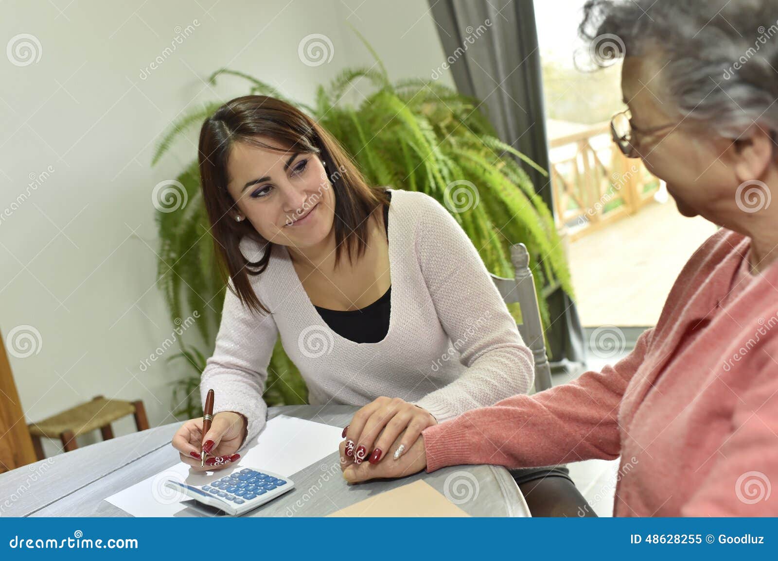 Home Helper Taking Care of Paperwork of Elderly Woman Stock Image