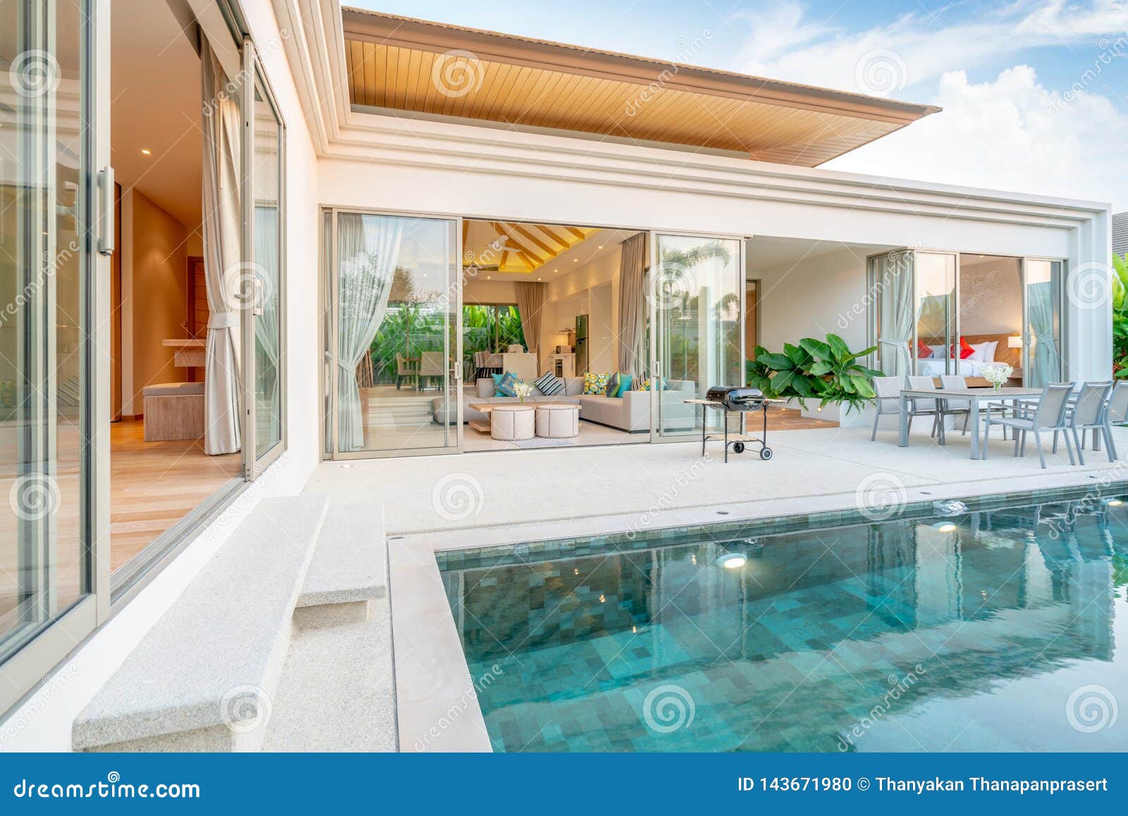 home or house exterior  showing tropical pool villa with greenery garden, sun bed, umbrella, pool towels