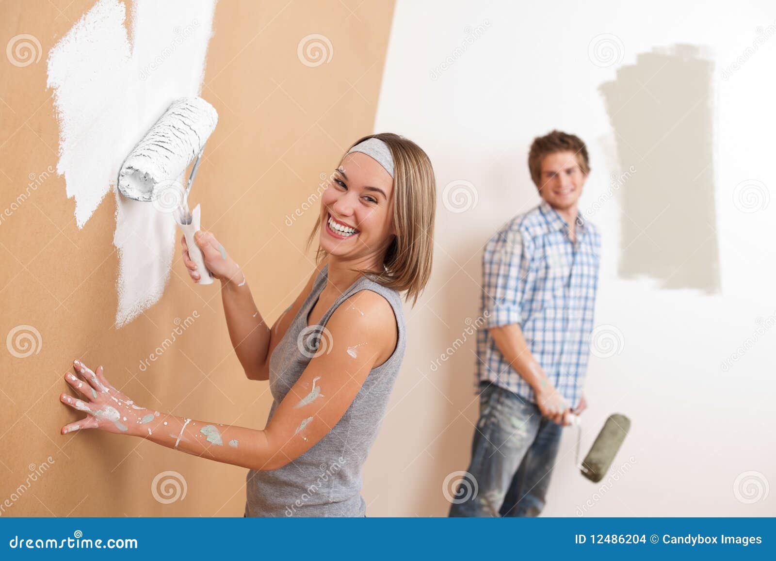 home improvement: young couple painting wall