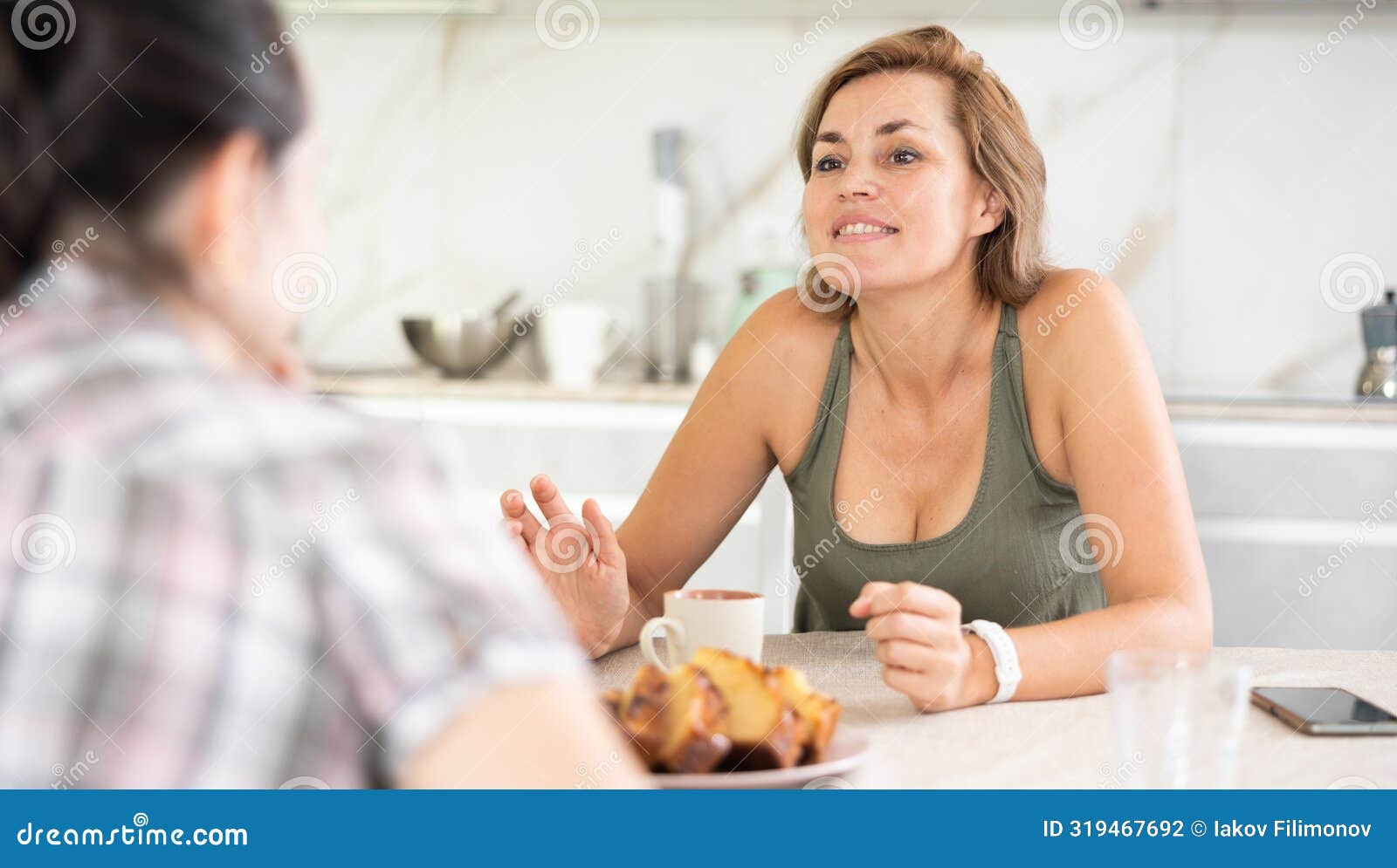 In Home Kitchen, Girlfriend Drink Tea and Have Nice Conversation