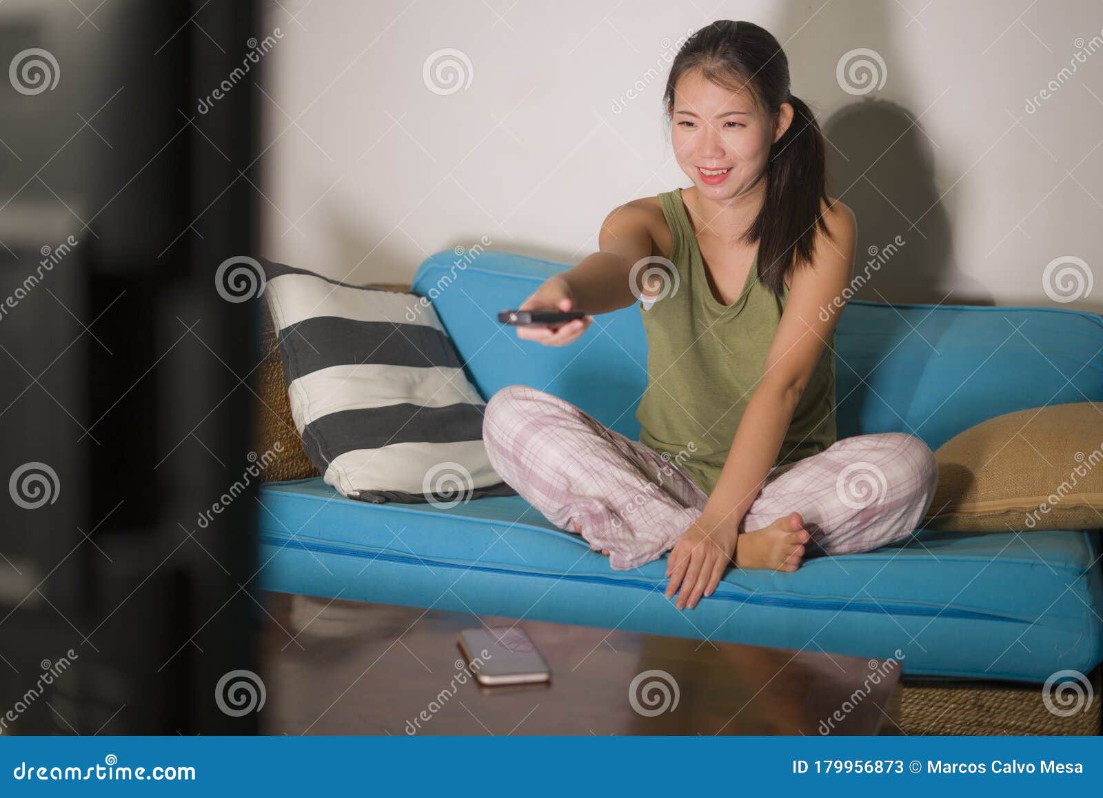 Young Happy And Beautiful Asian Korean Woman Watching TV ...