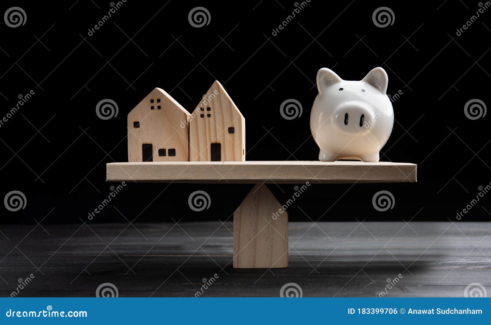 home loans market. model house and piggy bank balancing on a seesaw