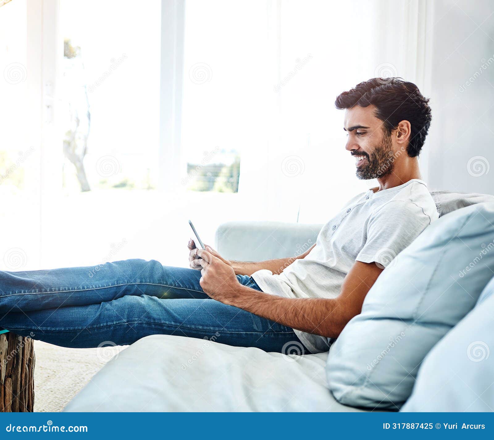 home, man and tablet on sofa for networking, chat and online conversation with contact. living room, male chatter and