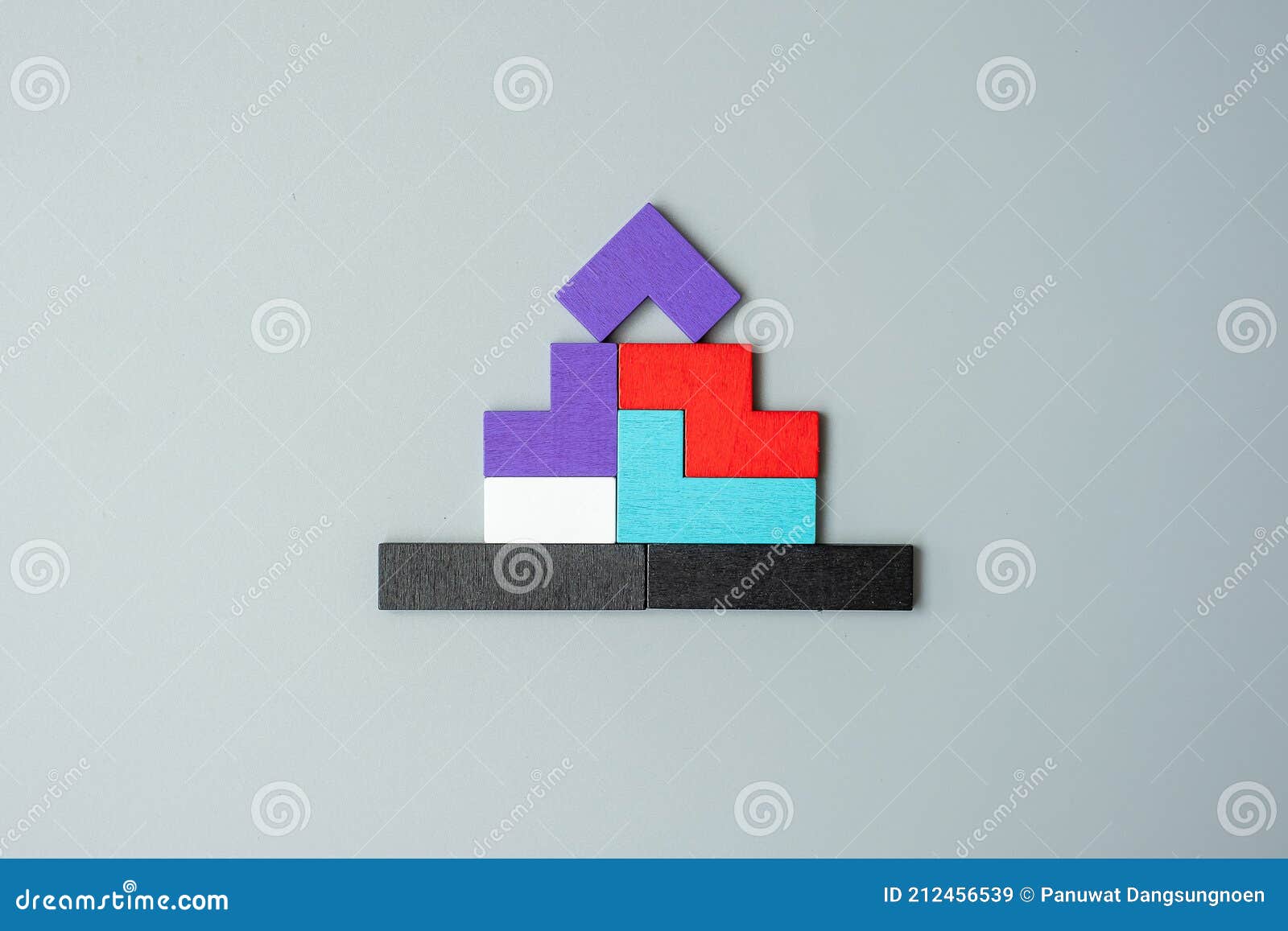 home  block with colorful wood puzzle pieces on gray background. logical thinking, business logic, solutions, rational, house