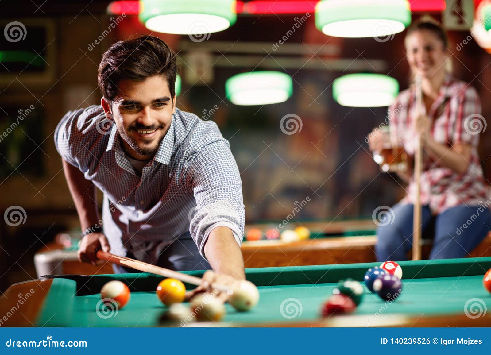 Mão do homem jogando sinuca no bar com bola de snooker