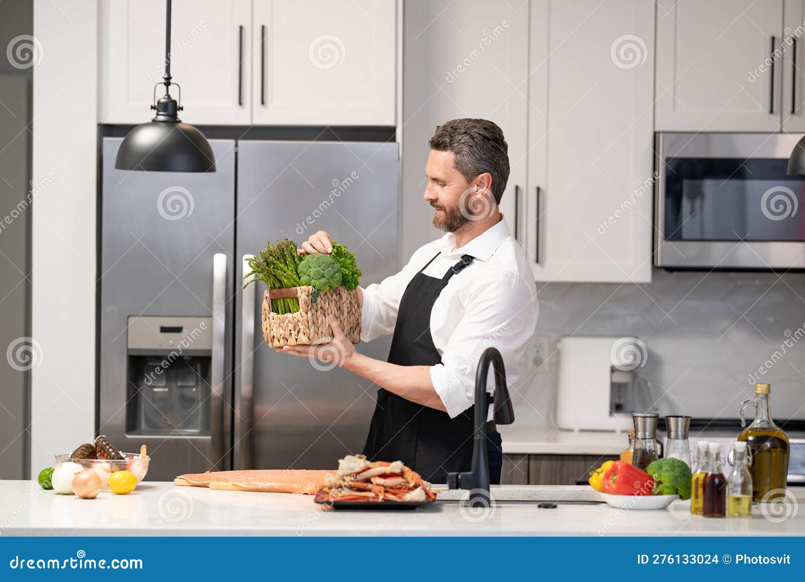 Homem Feliz Cozinhando Comida Saudável Usando Avental. Homem Cozinhando  Alimentos Saudáveis Na Cozinha. Foto de Stock - Imagem de avental,  gastronomia: 276133024
