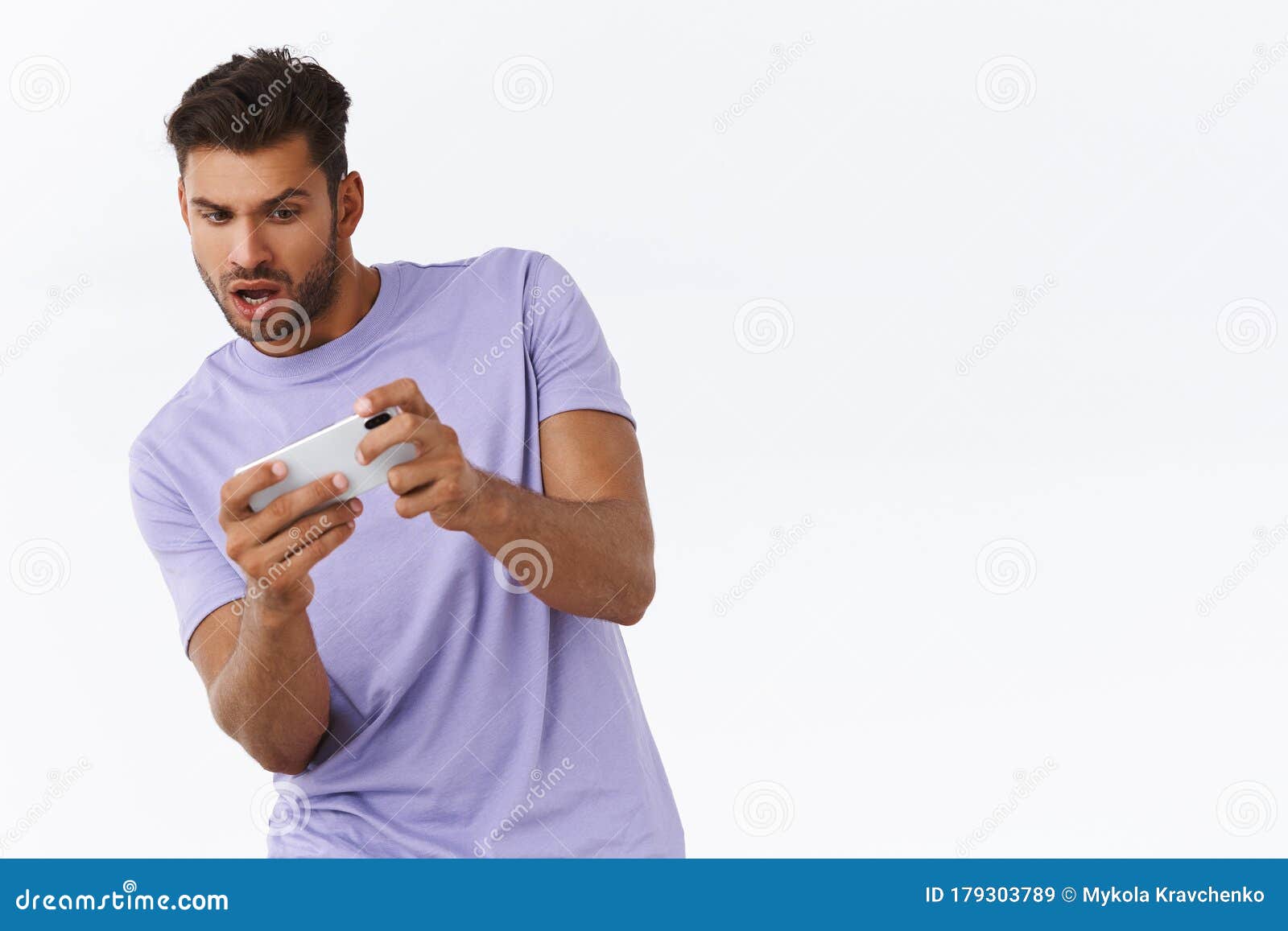 Focado jovem bonito jogando um jogo intenso segurando o celular