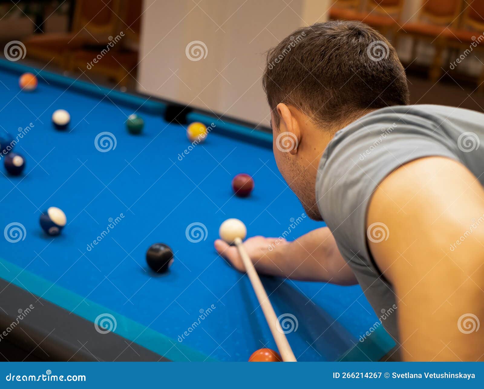 Mão do homem jogando sinuca no bar com bola de snooker