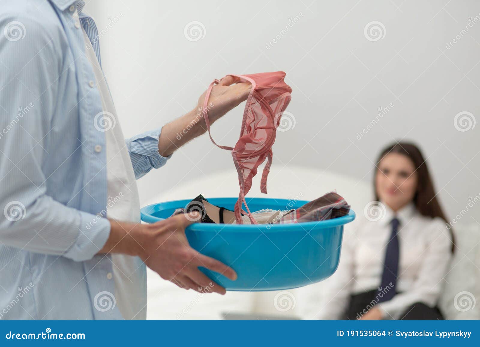 Lavanderia Feminina Enquanto O Homem Toca Tabuleiro Foto de Stock