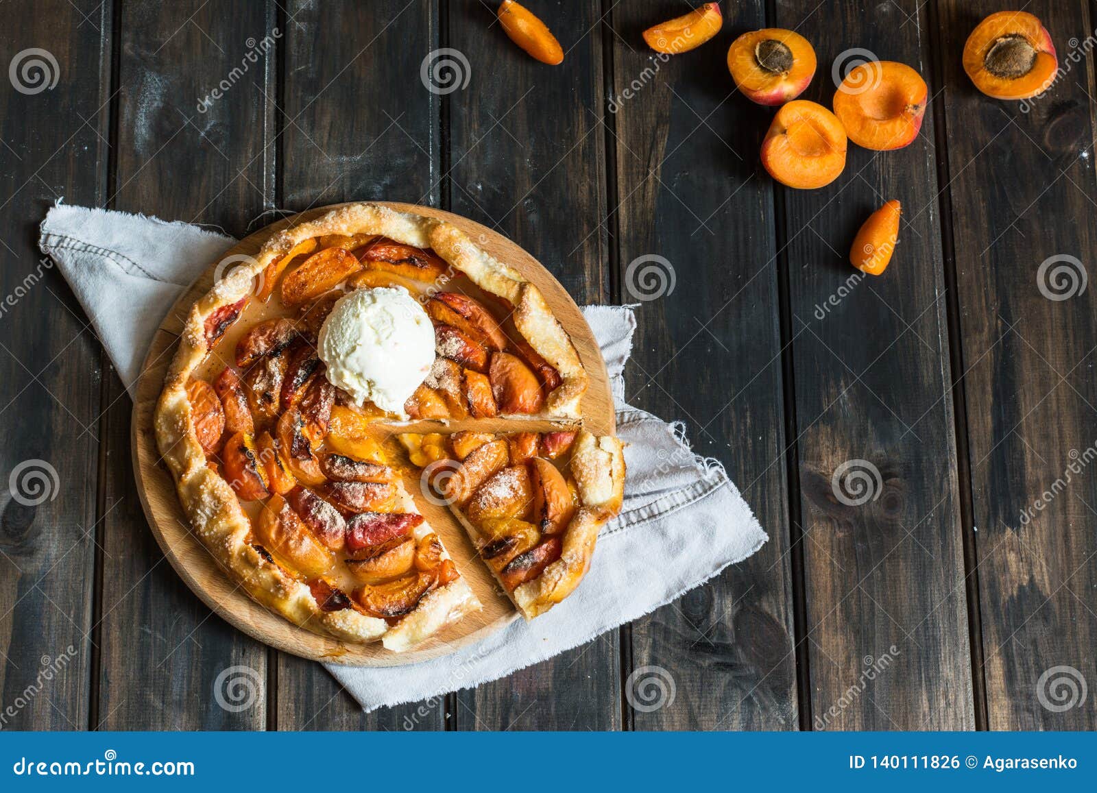 homemade apricot galette made with fresh organic apricotes on wooden table, top view. process of baking. open pie, apricot tart.