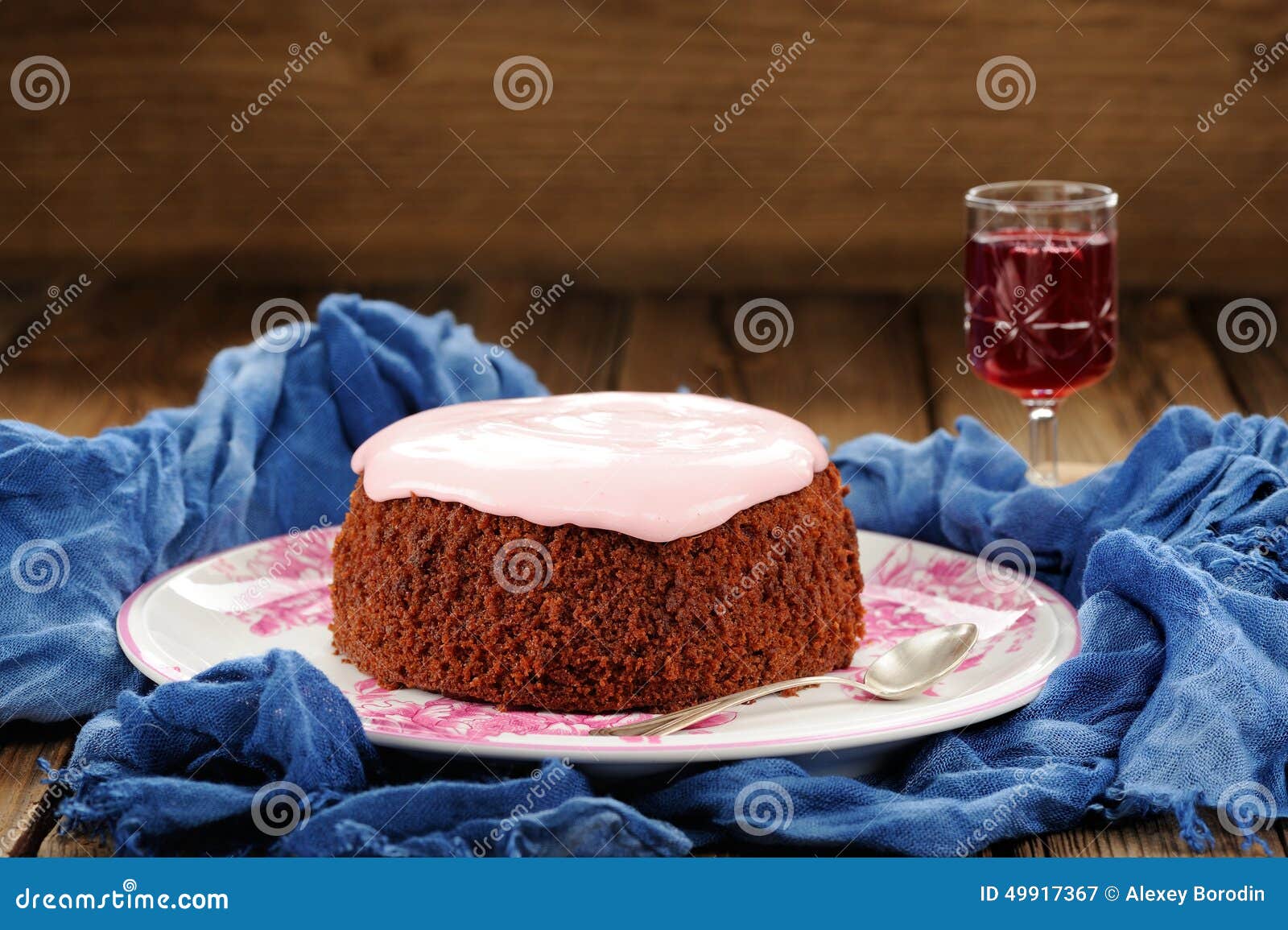 Homemade Cake with Pink Icing and Wine on Blue Background Stock Image