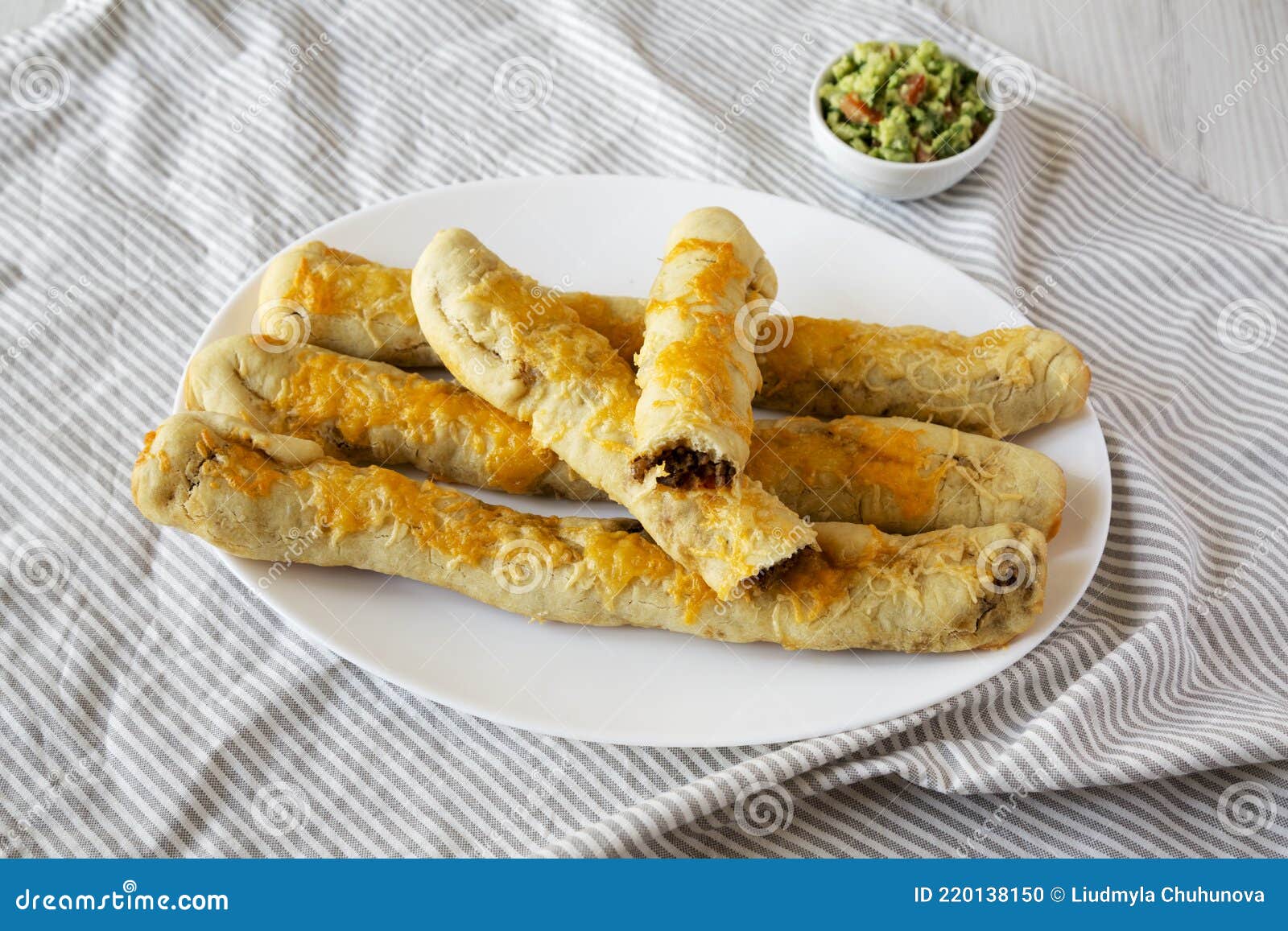 Homemade Cheesy Taco Breadsticks with Guacamole, Side View Stock Photo