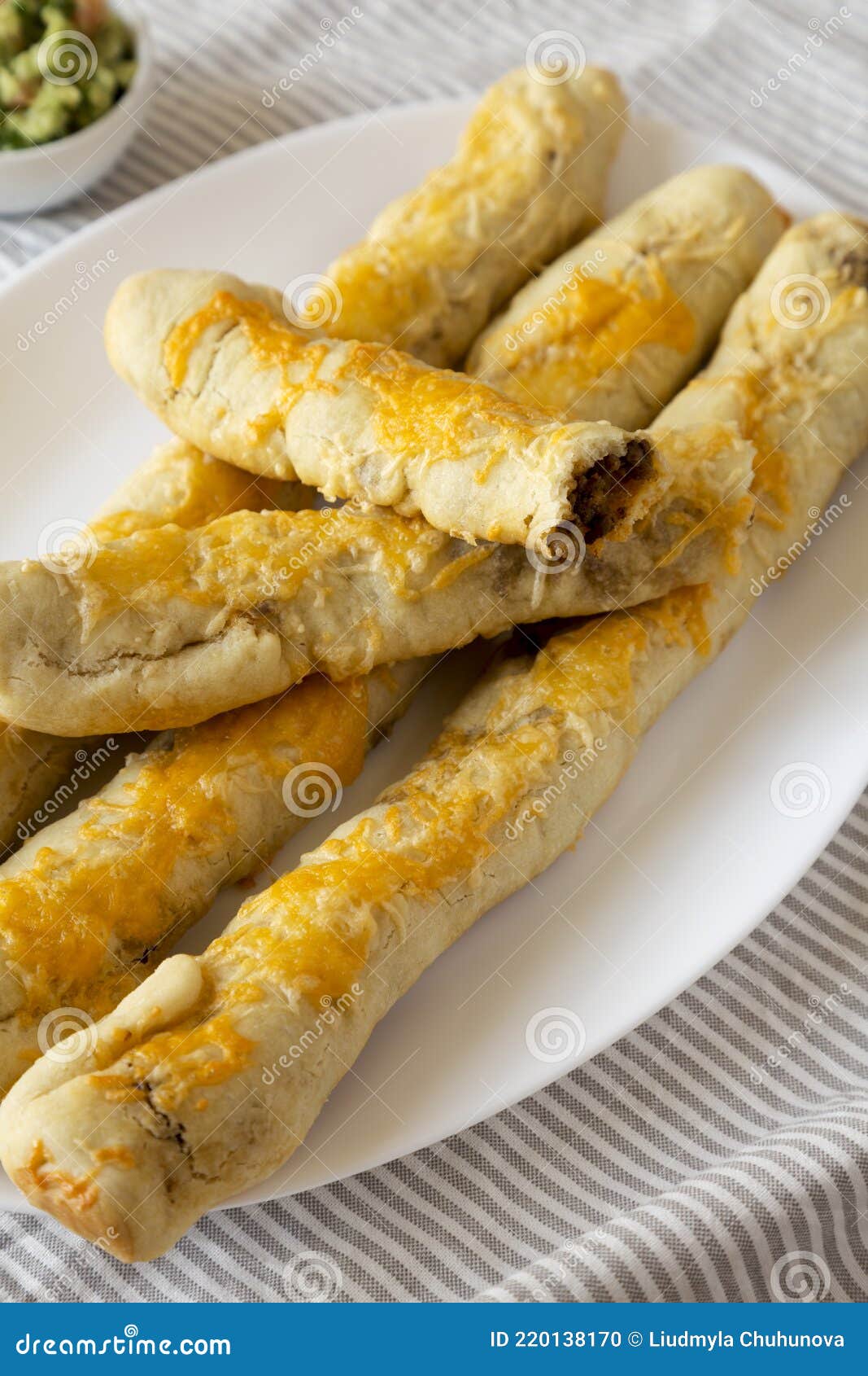 Homemade Cheesy Taco Breadsticks with Guacamole, Side View Stock Photo
