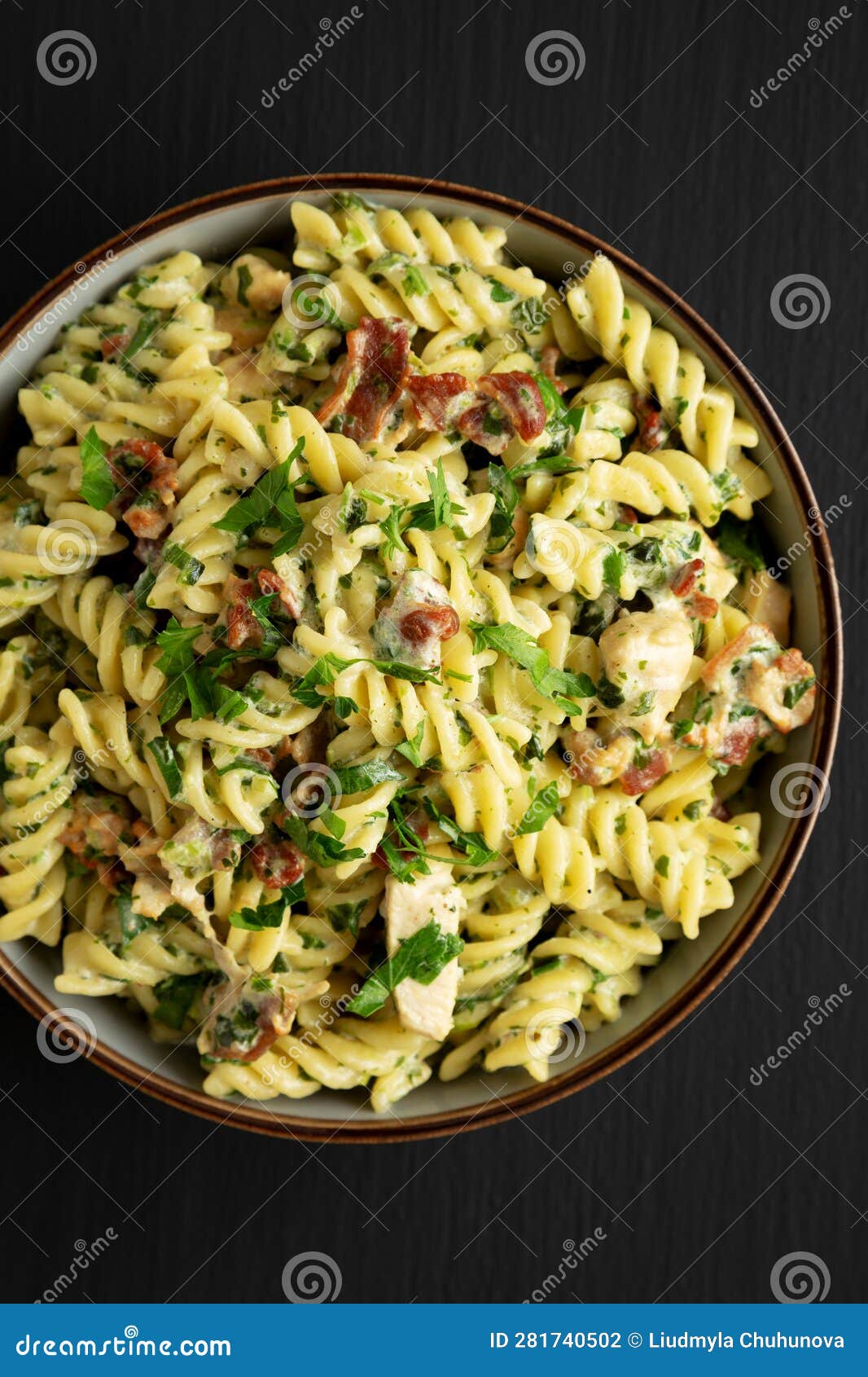 Homemade Chicken Spinach Alfredo Rotini Pasta in a Bowl on a Black