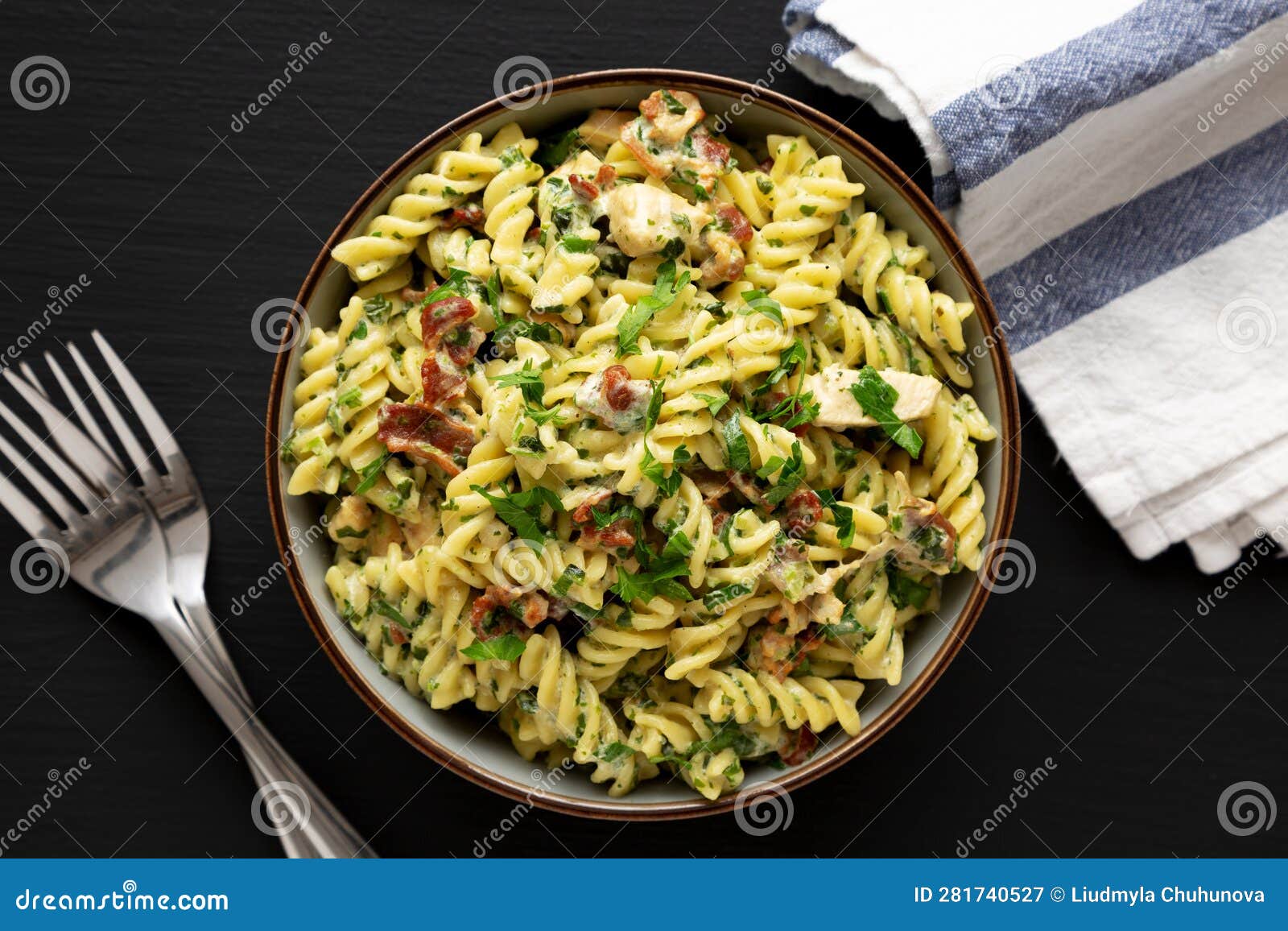 Homemade Chicken Spinach Alfredo Rotini Pasta in a Bowl on a Black