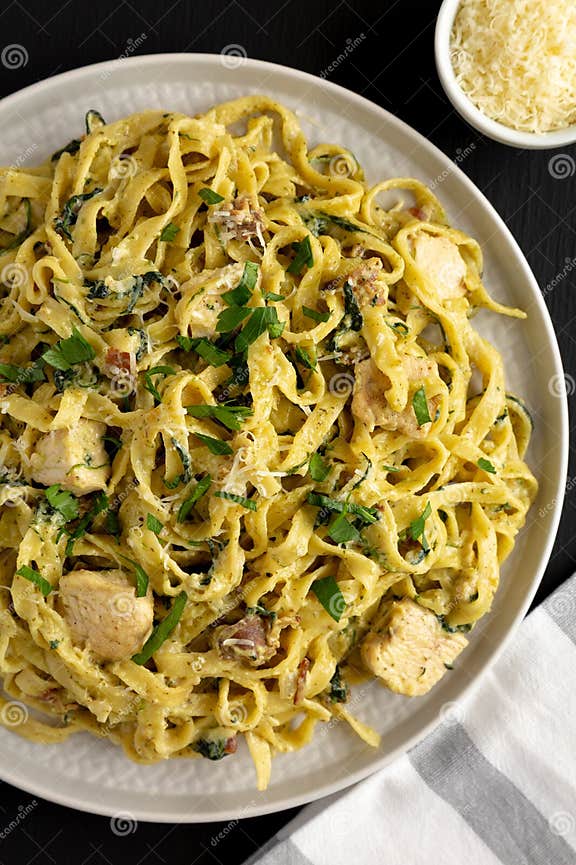 Homemade Creamy Chicken Bacon Pesto Pasta on a Plate on a Black
