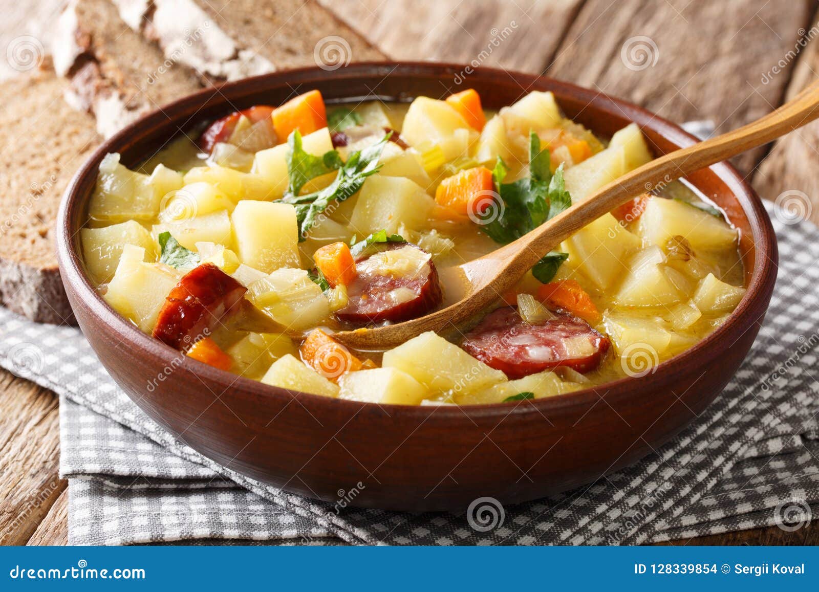 Homemade German Hot Potato Soup with Sausages in a Bowl Closeup