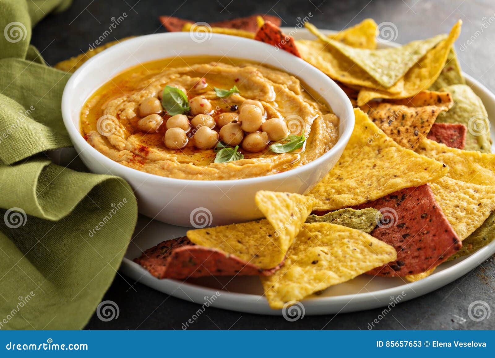 Homemade Hummus in White Bowl with Rainbow Corn Chips Stock Image