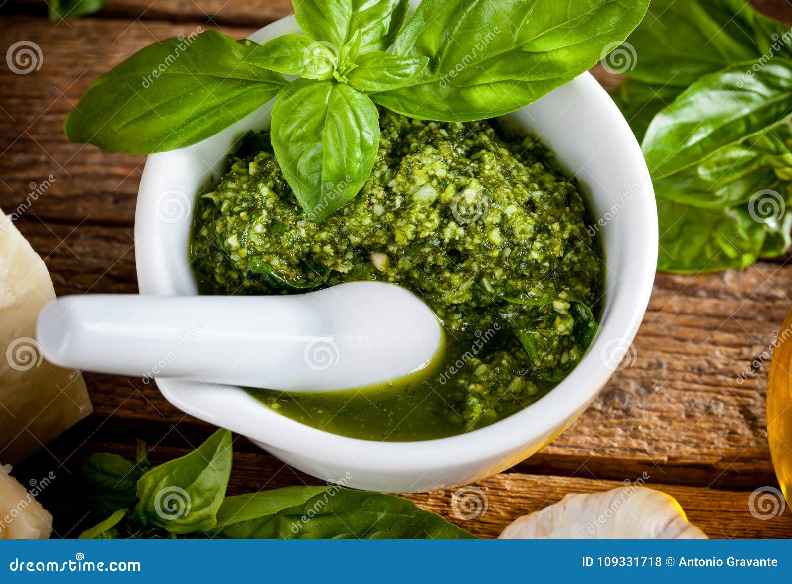 Homemade Pesto Sauce with Basil and Pine Nuts in White Mortar Stock Homemade Pesto Sauce with Basil and Pine Nuts in White Mortar Stock