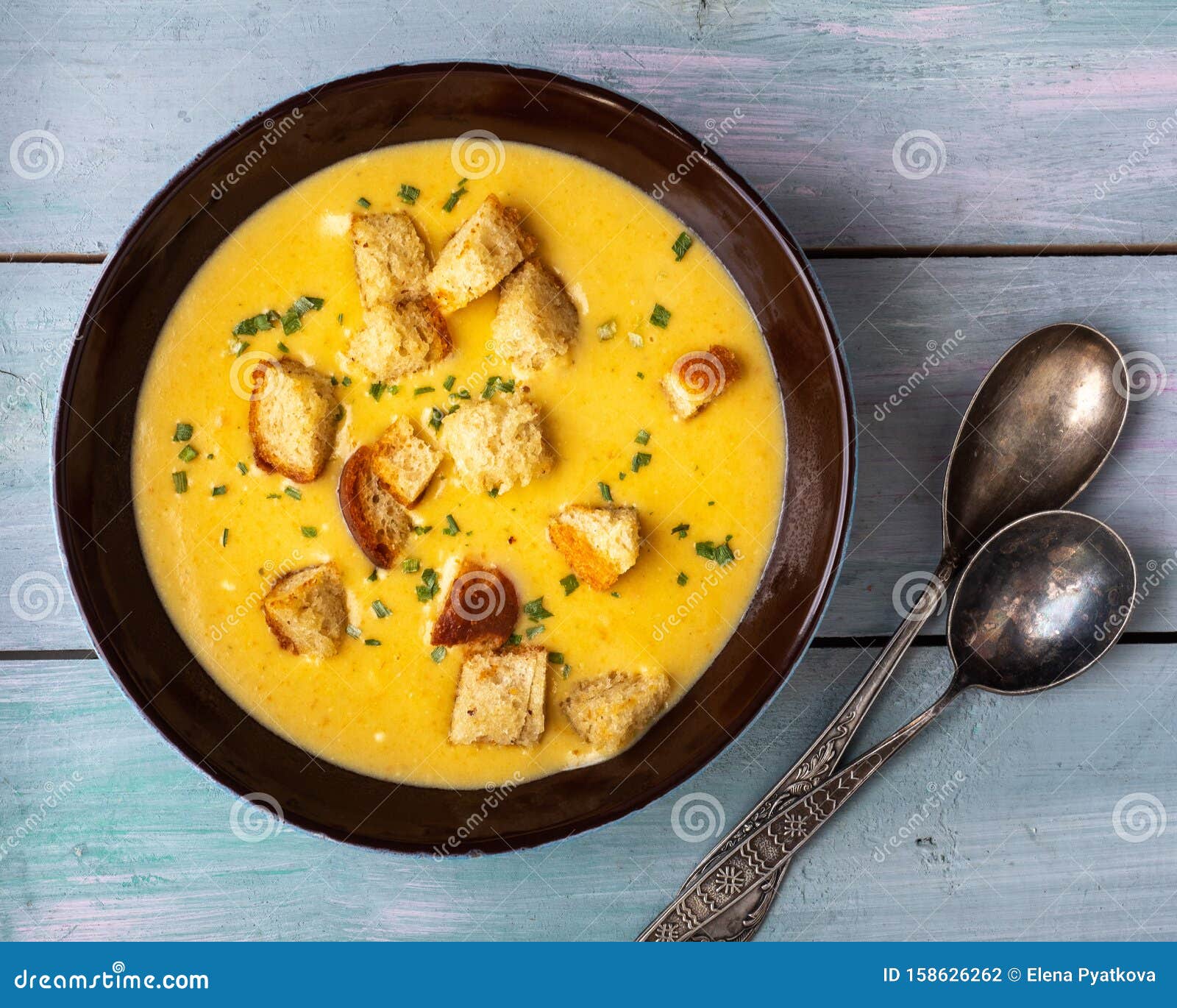 homemade soup-mashed vegetables in mushroom broth with croutons in a deep dish and tablespoons