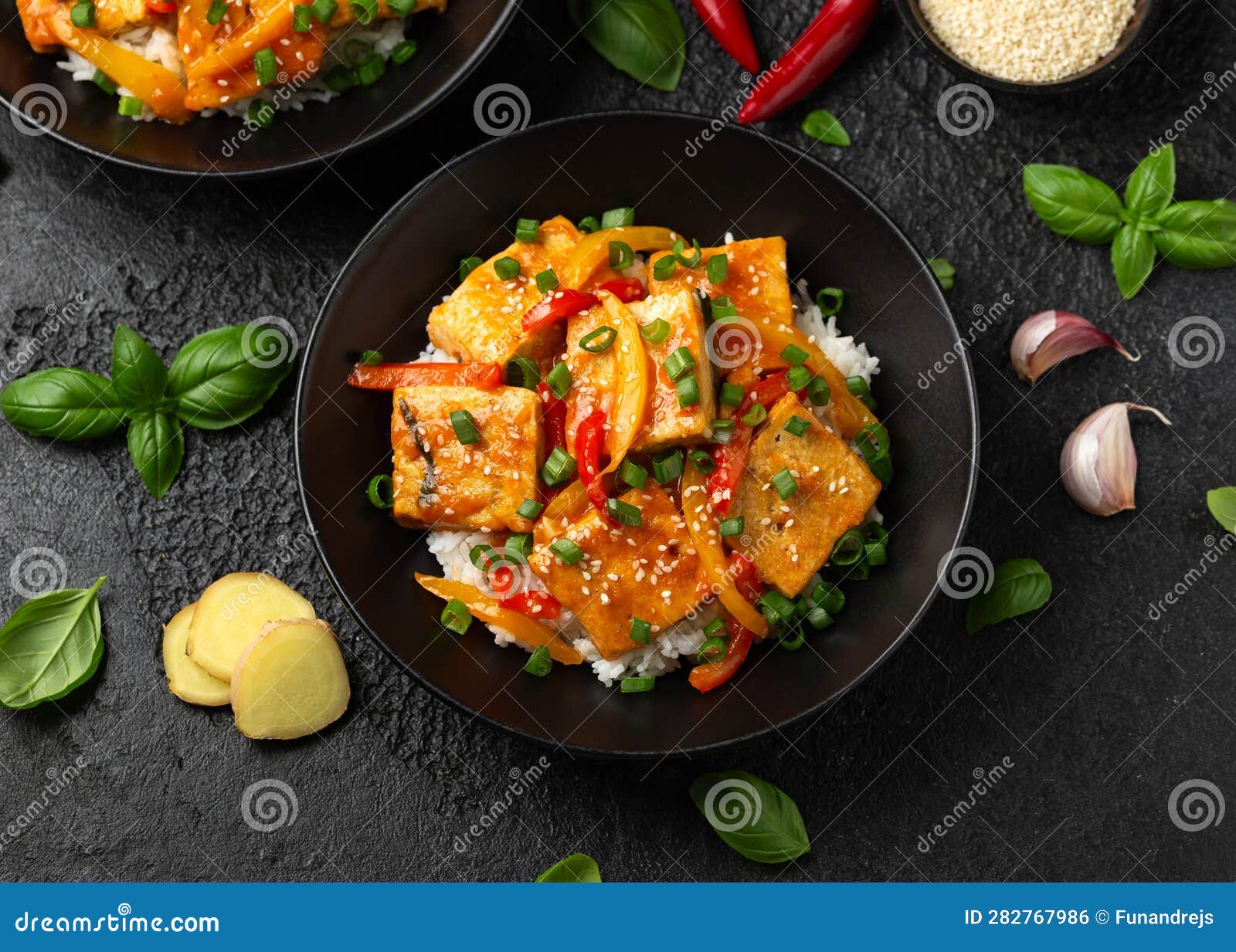 Homemade Stir Fry Tofu with Vegetables and Rice in Black Bowl. Stock