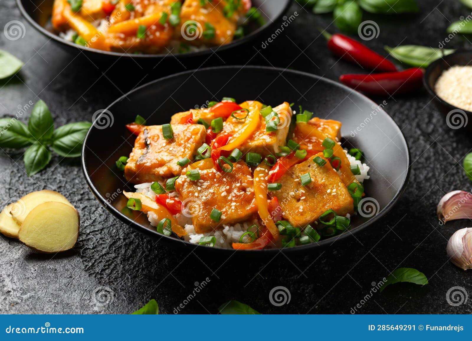 Homemade Stir Fry Tofu with Vegetables and Rice in Black Bowl Stock