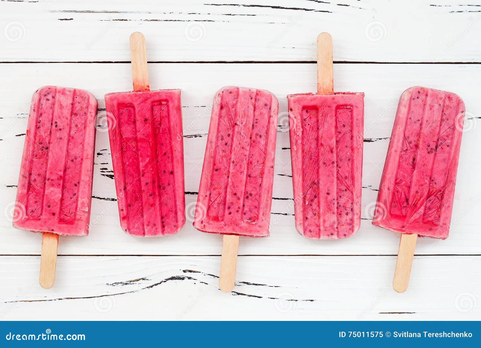 homemade vegan raspberry coconut milk popsicles - ice pops - paletas with chia seeds on rustic white wooden background.
