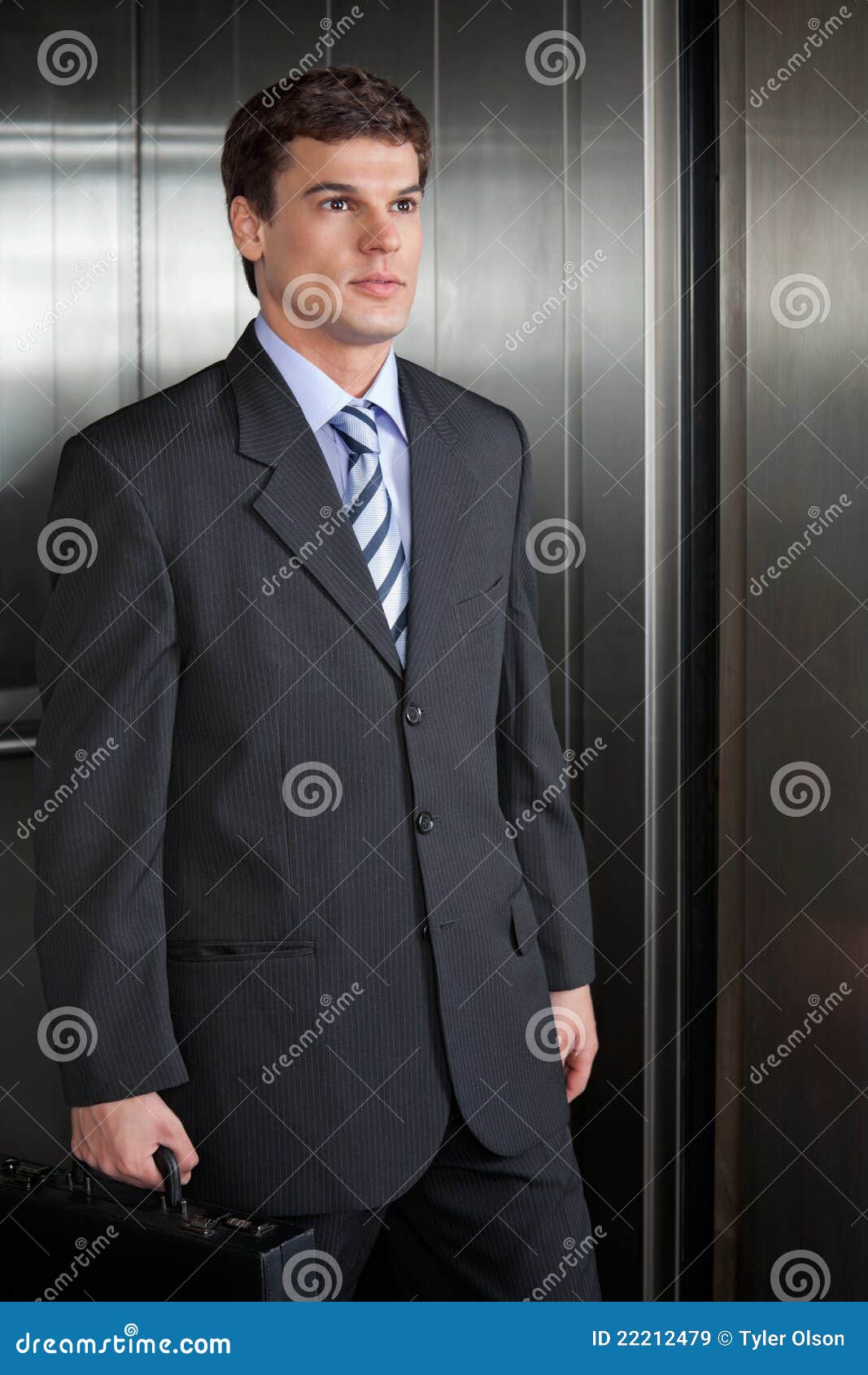 Homens de negócios que andam para fora do elevador. Homem de negócios confiável que anda para fora da pasta da terra arrendada do elevador