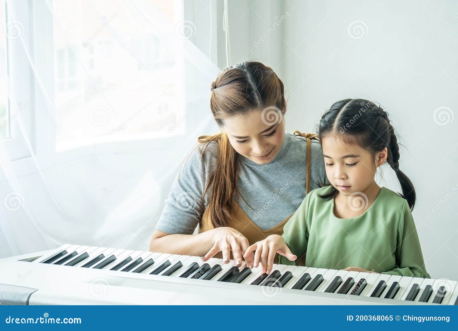 Linda garota asiática aprendendo música de piano online com