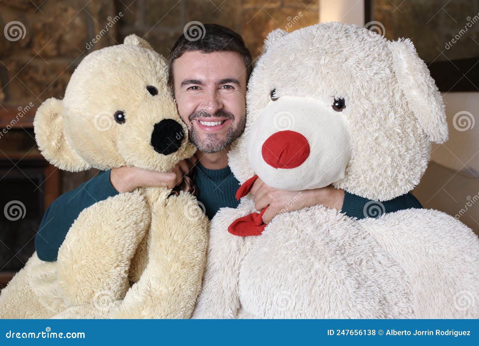 homme adulte dans une chemise noire tient un ours en peluche brun