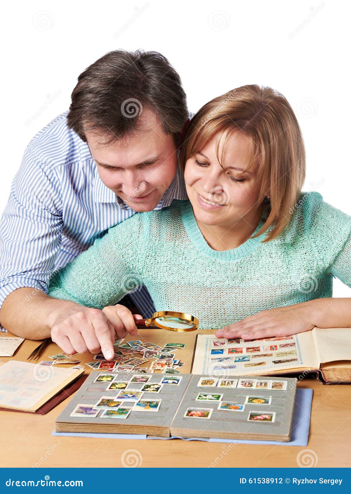 Homme et femme observant une collection de timbres-poste. Homme et femmes observant une collection de timbres-poste d'isolement