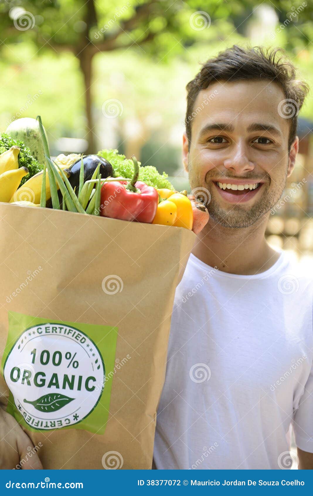 Homme heureux portant un sac d'aliment biologique. Homme heureux portant un sac complètement d'aliment biologique.