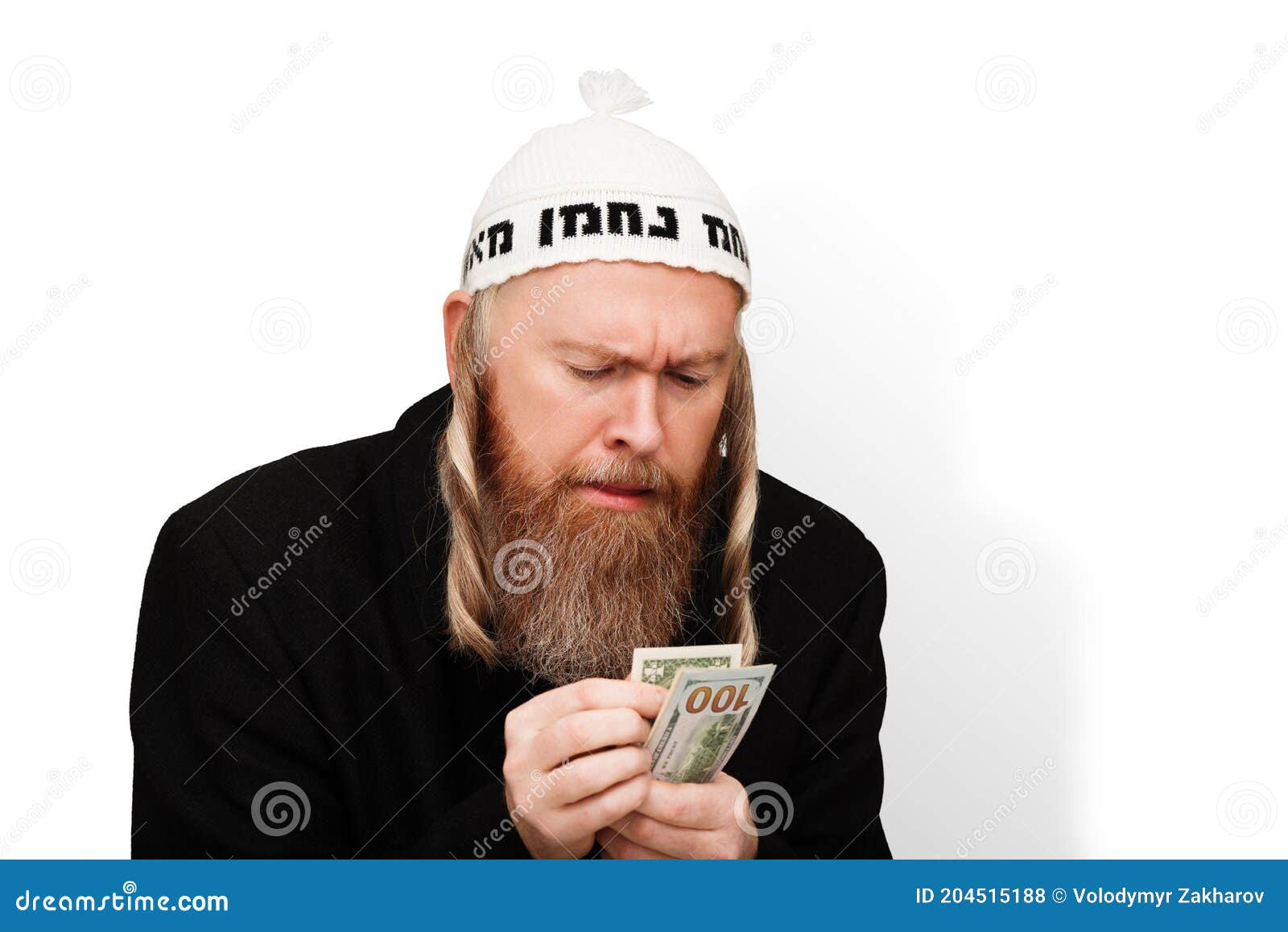 Homme juif barbu avide son argent en liquide. Juif économe avec sidelocks dans la kippa blanche isolée sur le fond blanc