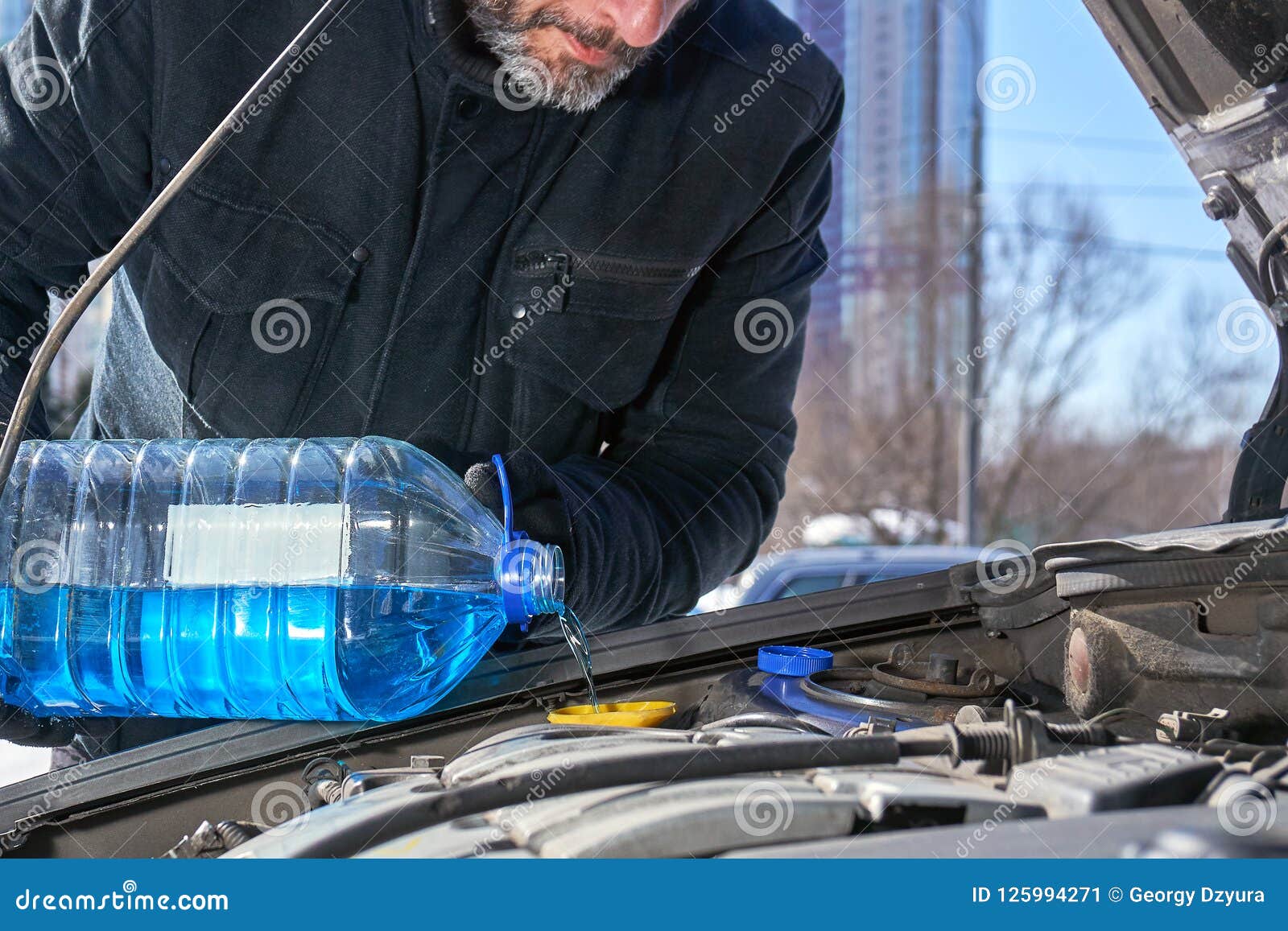 Homme Remplissant Réservoir De Joint De Pare-brise D'une Voiture Par L' antigel Sur La Rue De Moscou D'hiver Image stock - Image du voiture,  changement: 125994271