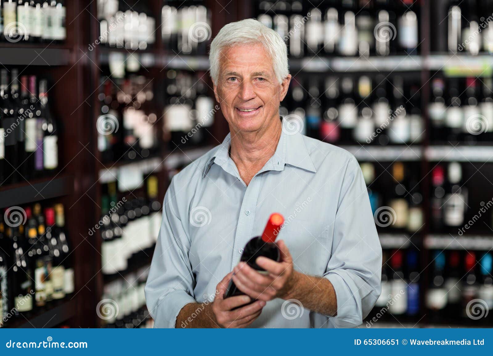 Homme supérieur de sourire choisissant le vin
