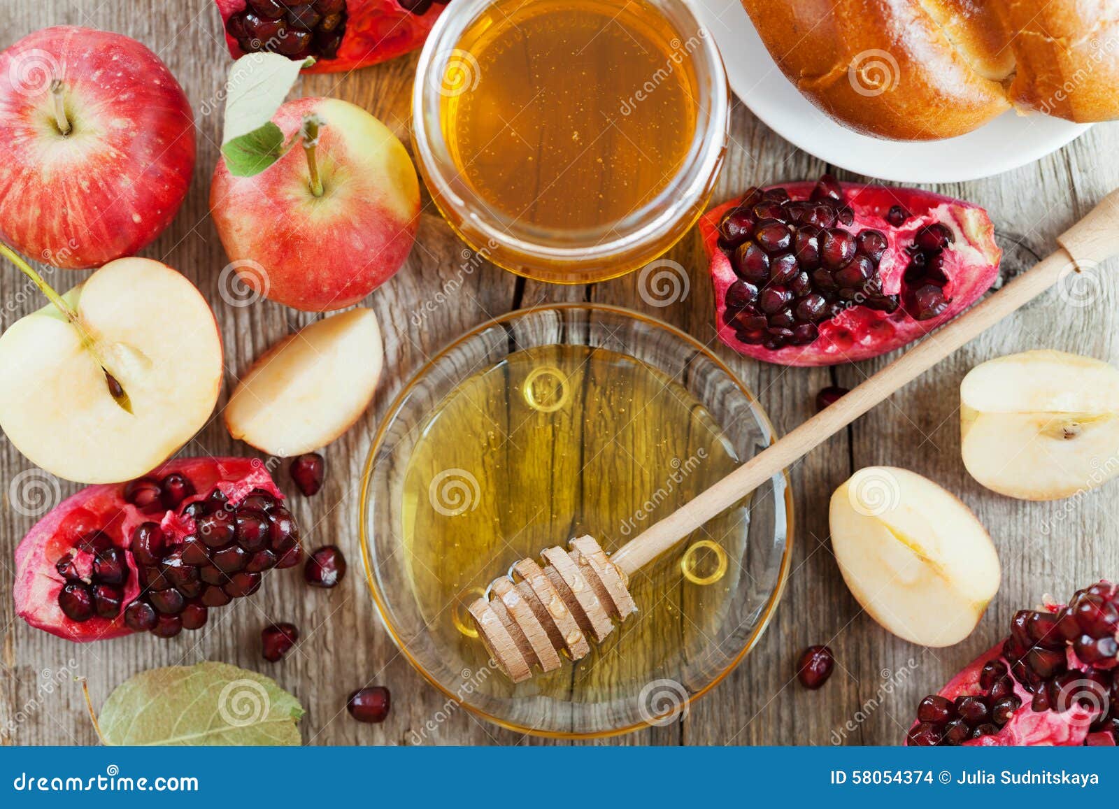 honey, apple, pomegranate and bread hala, table set with traditional food for jewish new year holiday, rosh hashana