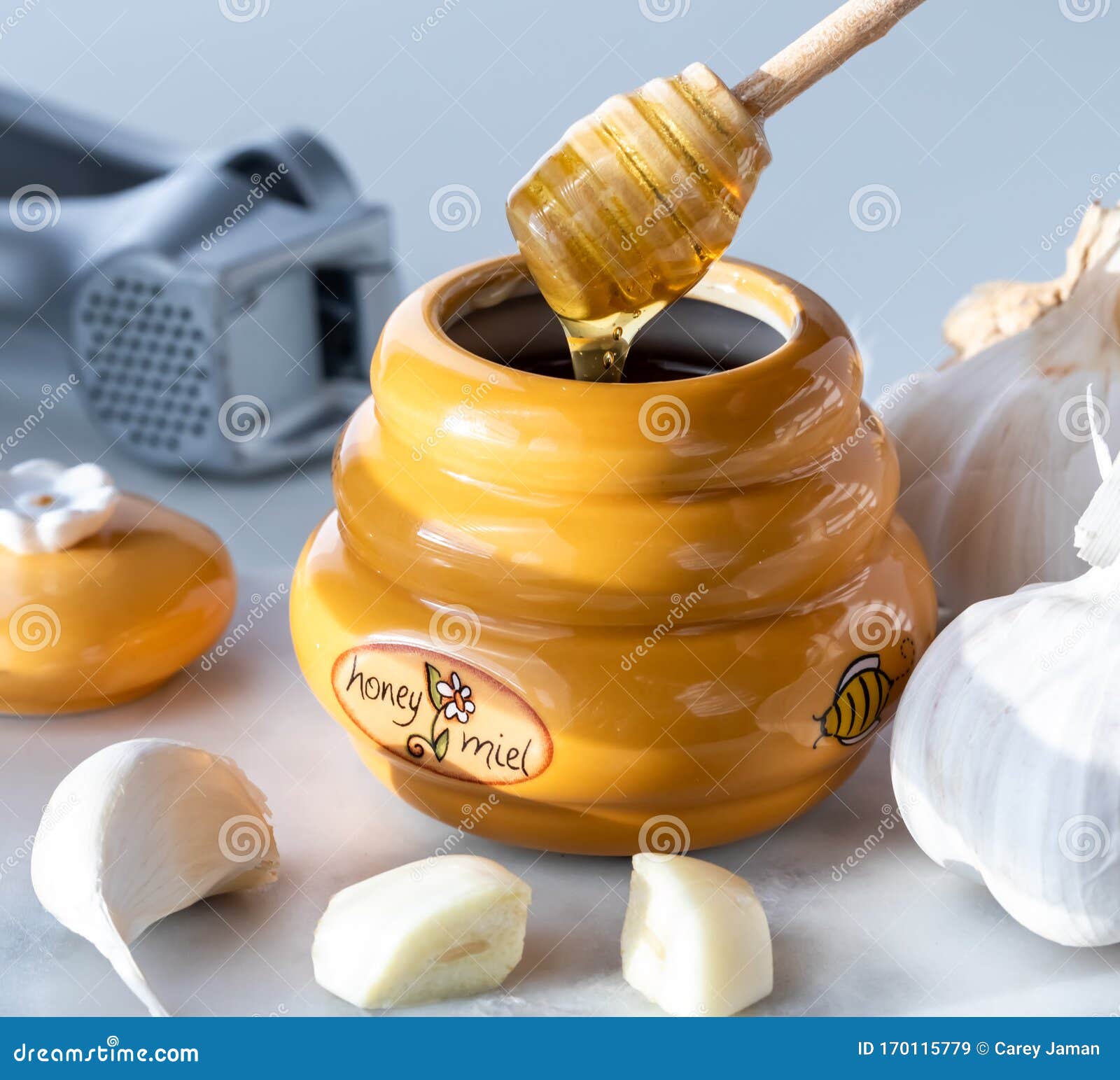 A Close Up View of a Honey Pot with a Dipper Dripping Honey and