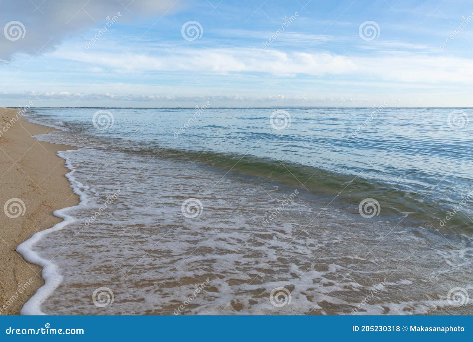 horizontal background of gentle waves on a golden sandy tropical beach