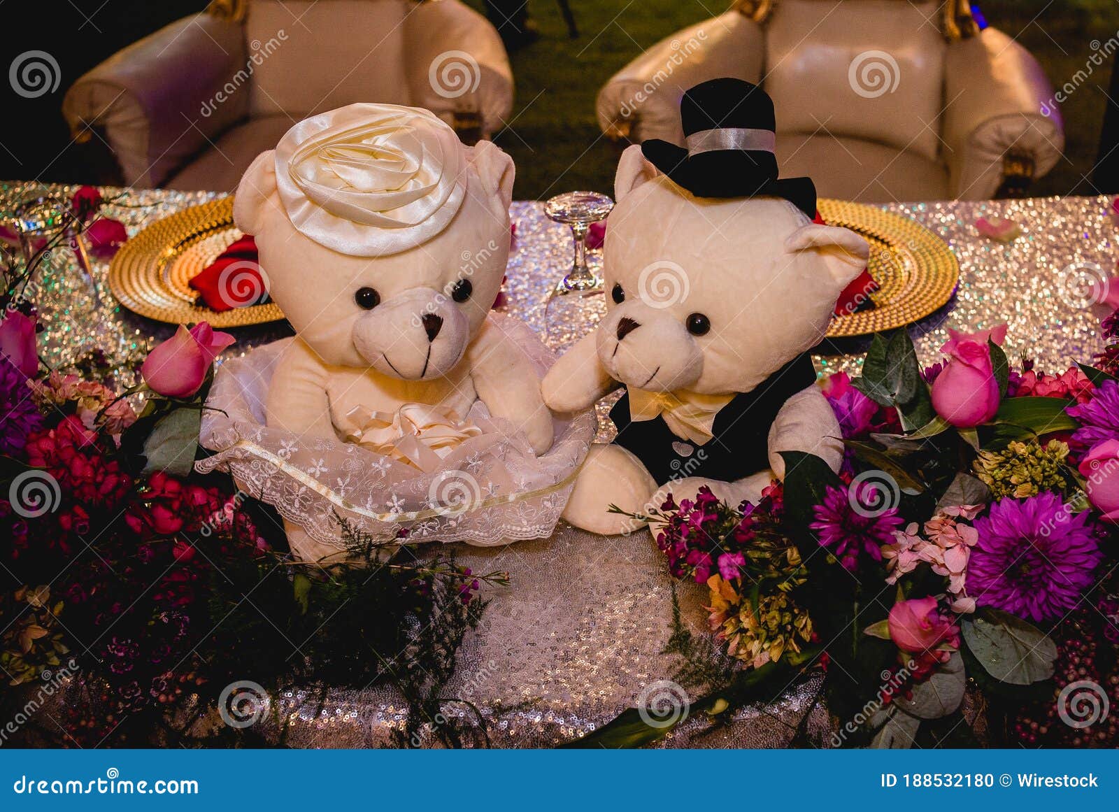 horizontal shot of two white stuffed bears dressed as bride and groom on a decorated wedding table