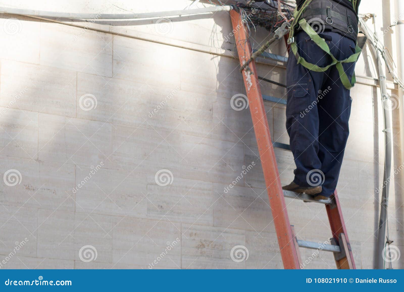 horizontal view of a tecnician working on a ladder with safety t