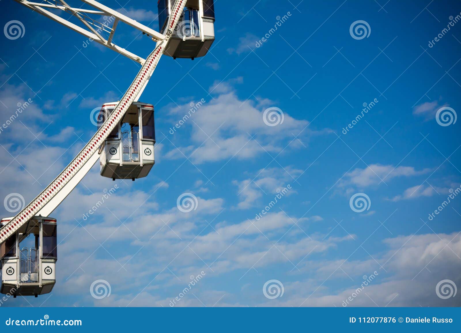 Horizontal View of a White Ferris Wheel on Partially Cloudy Sky Stock