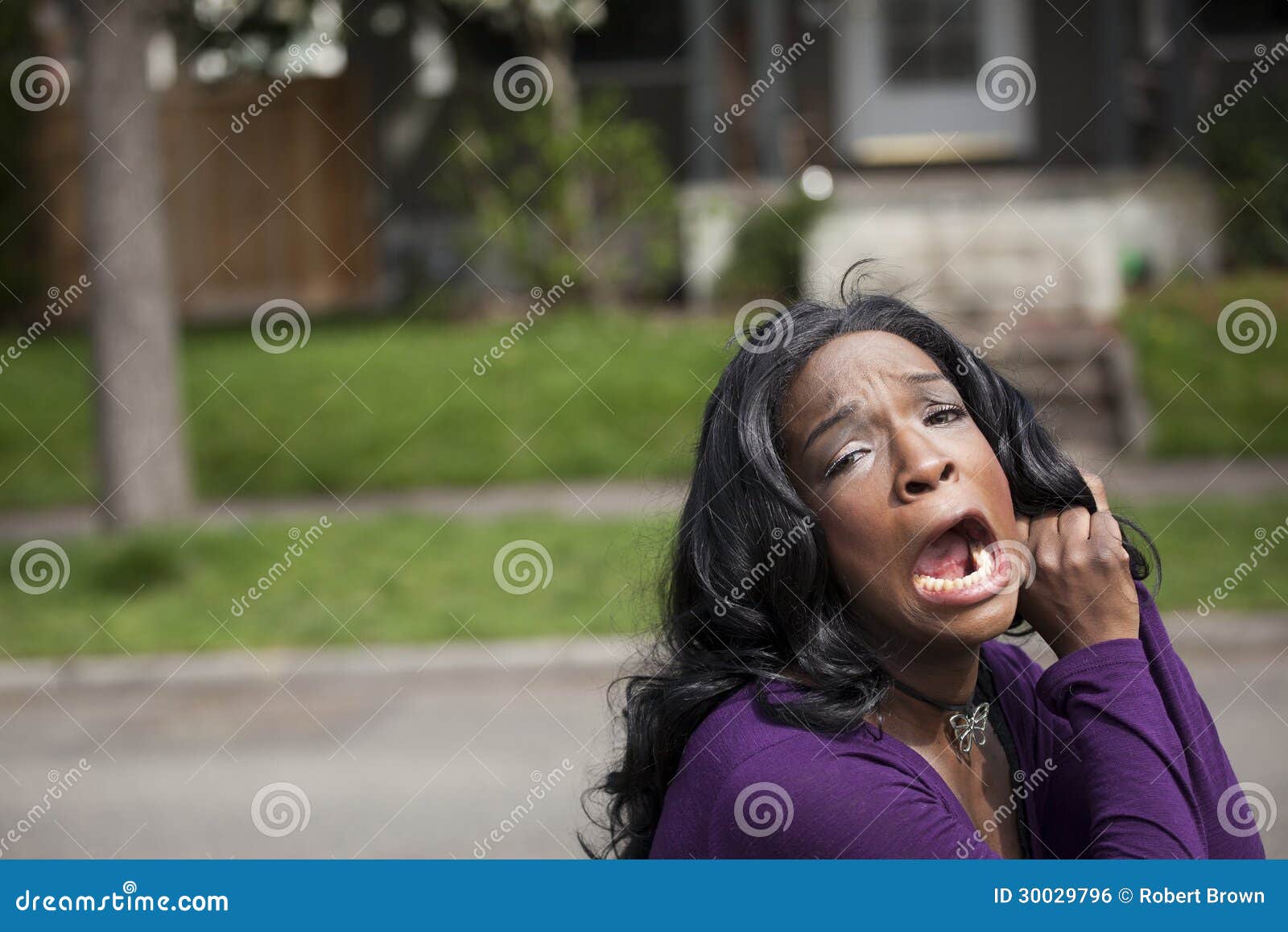 horrified young african american woman in purple top