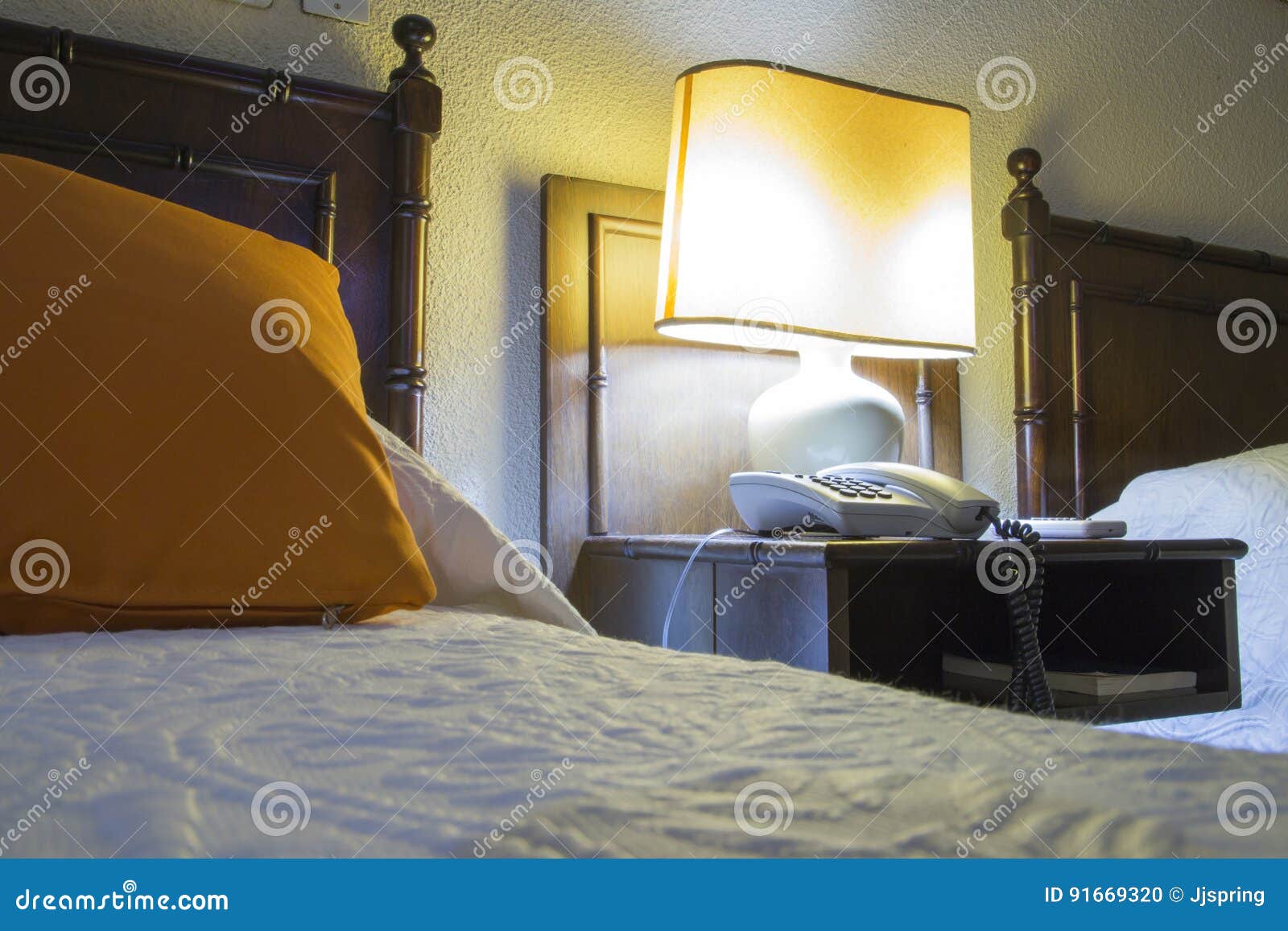hostel with beds, nightstand and lamp at night