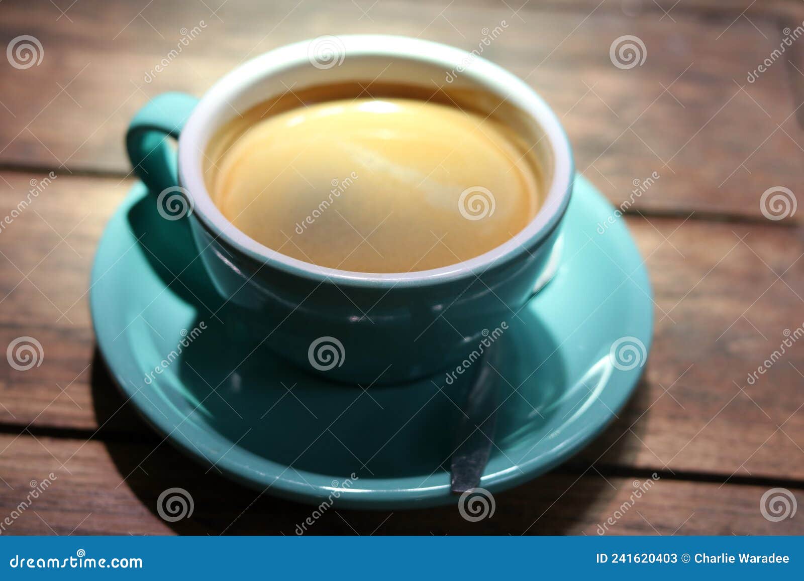 hot black coffee in blue ceramic cup on wooden table background.