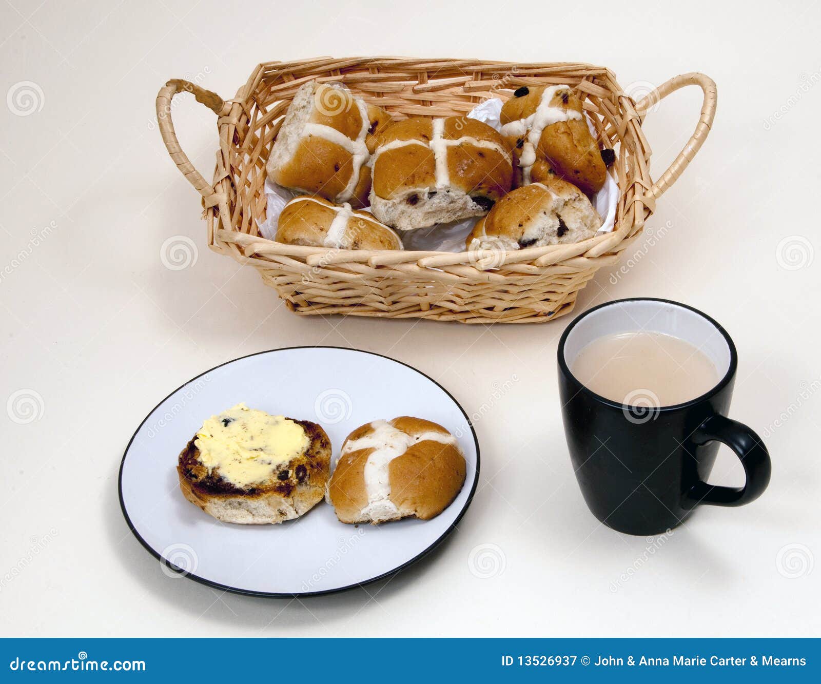 Hotcross Buns in a Basket and Cup of Tea on a White Background. Stock