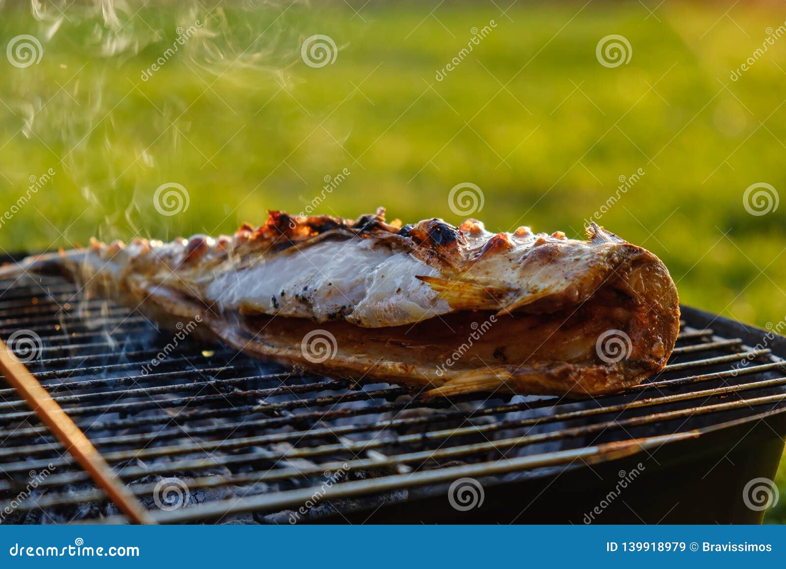 Hot Mackerel Fish on a Grilling Pan, with Herb Spices on Fire Stock
