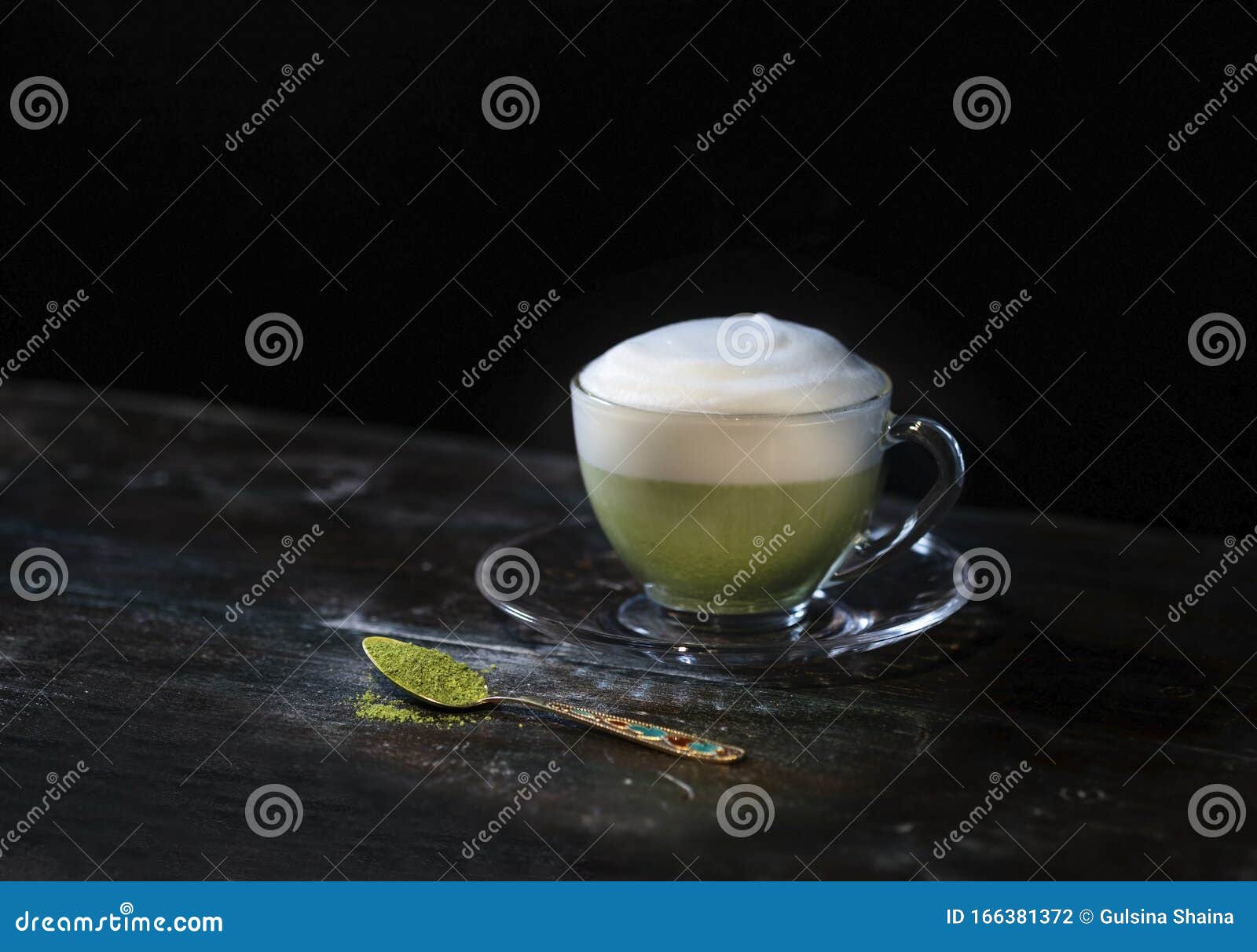 hot matcha green tea latte in a cupon a dark background. fashionable energy tea