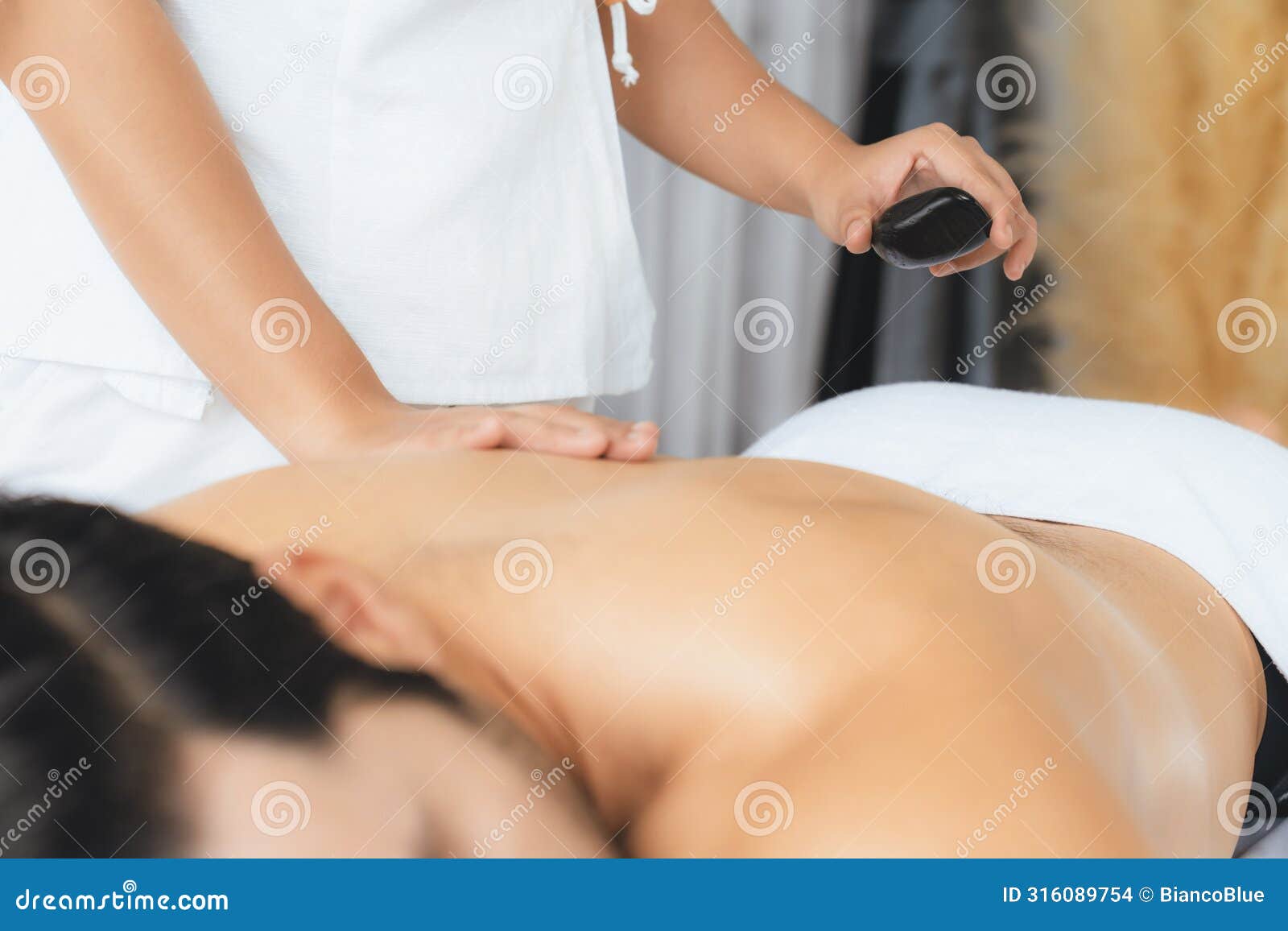 hot stone massage at spa salon in luxury resort. quiescent