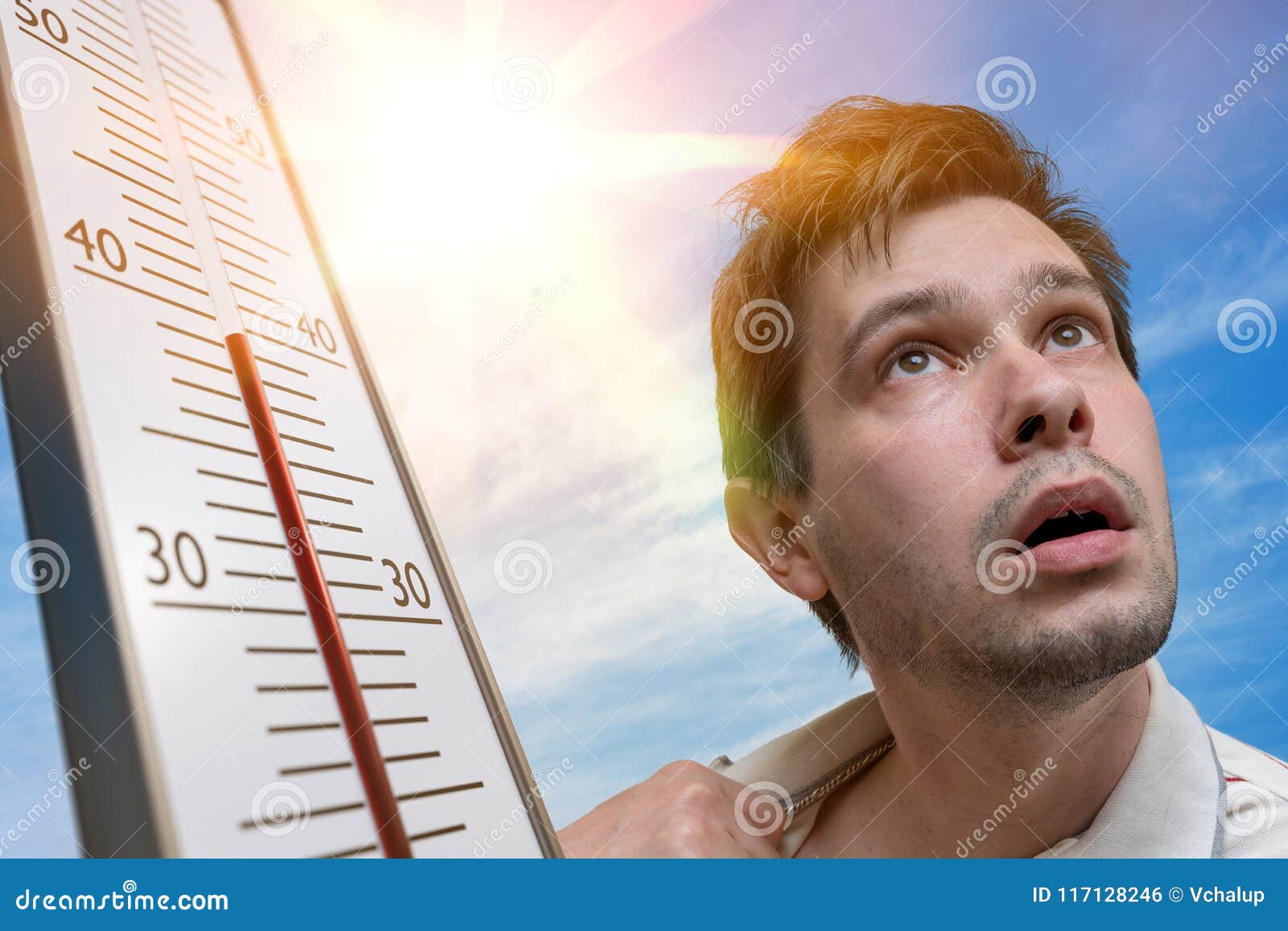 hot weather concept. young man is sweating. thermometer is showing high temperature. sun in background